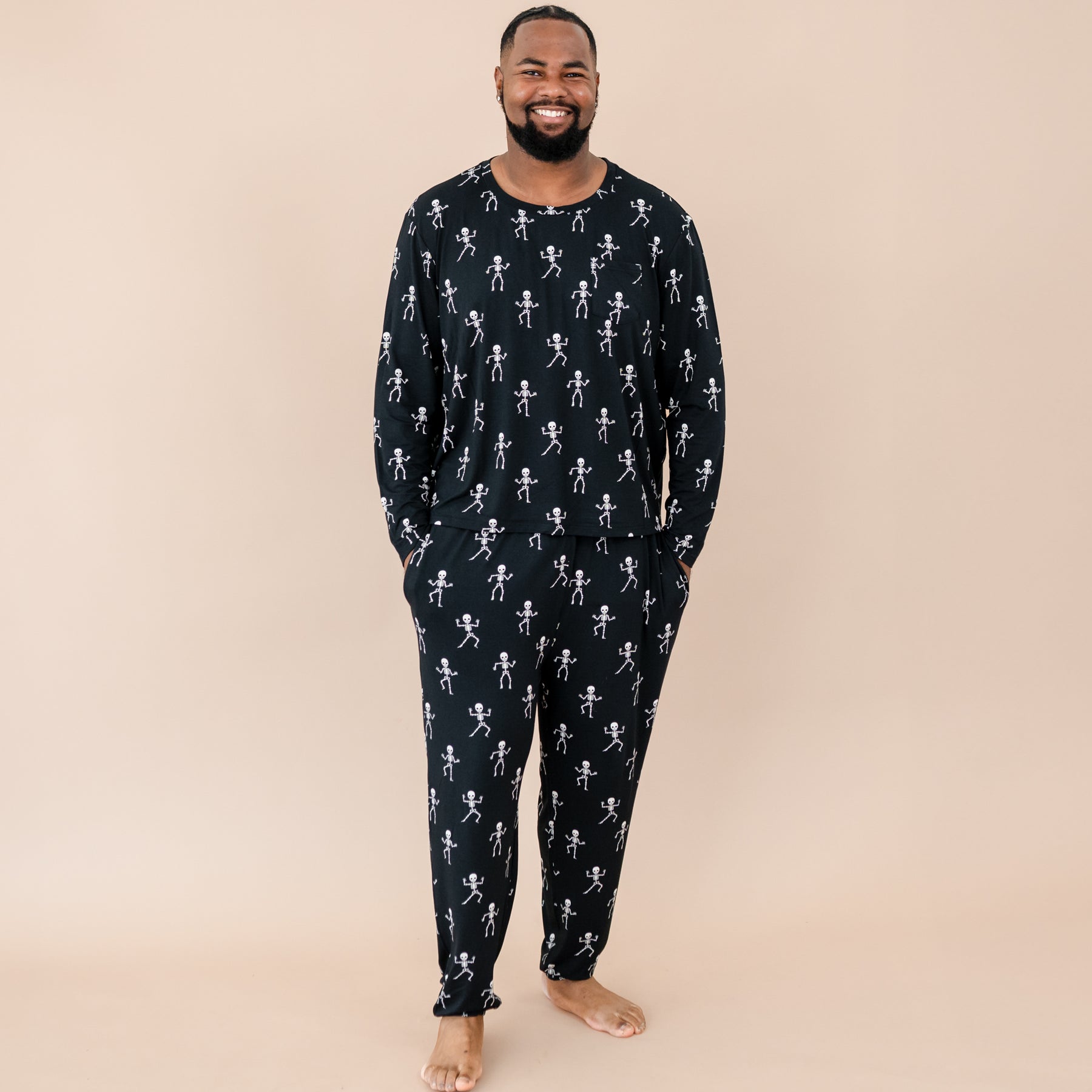 Smiling male model wearing the Men's Jogger Set in Skeleton in front of a beige backdrop