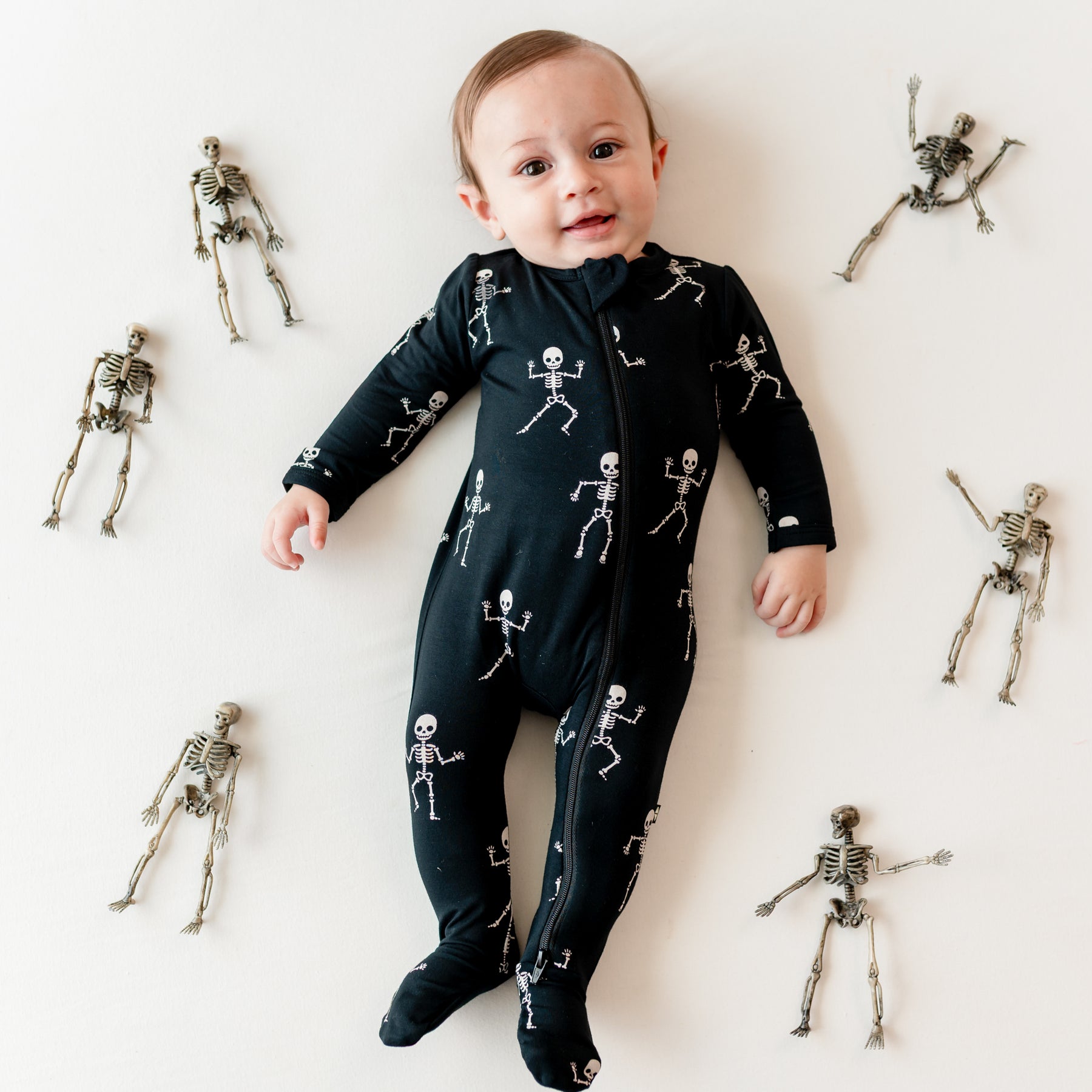 Infant wearing bamboo Zippered Footie in Skeleton