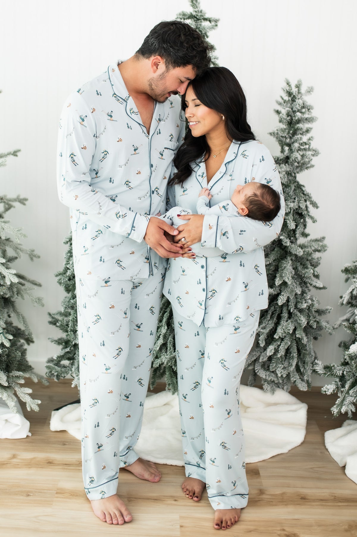 Family of three standing wearing matching pajamas from the Ski collection