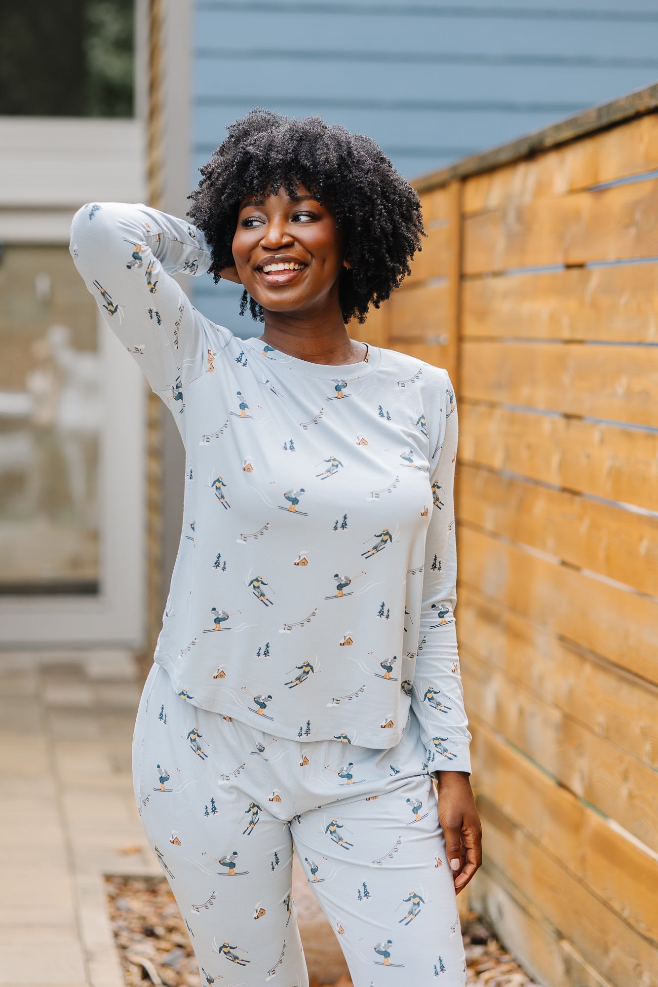 Smiling model wearing the Women's Jogger Pajama Set in Ski with one hand up behind her head