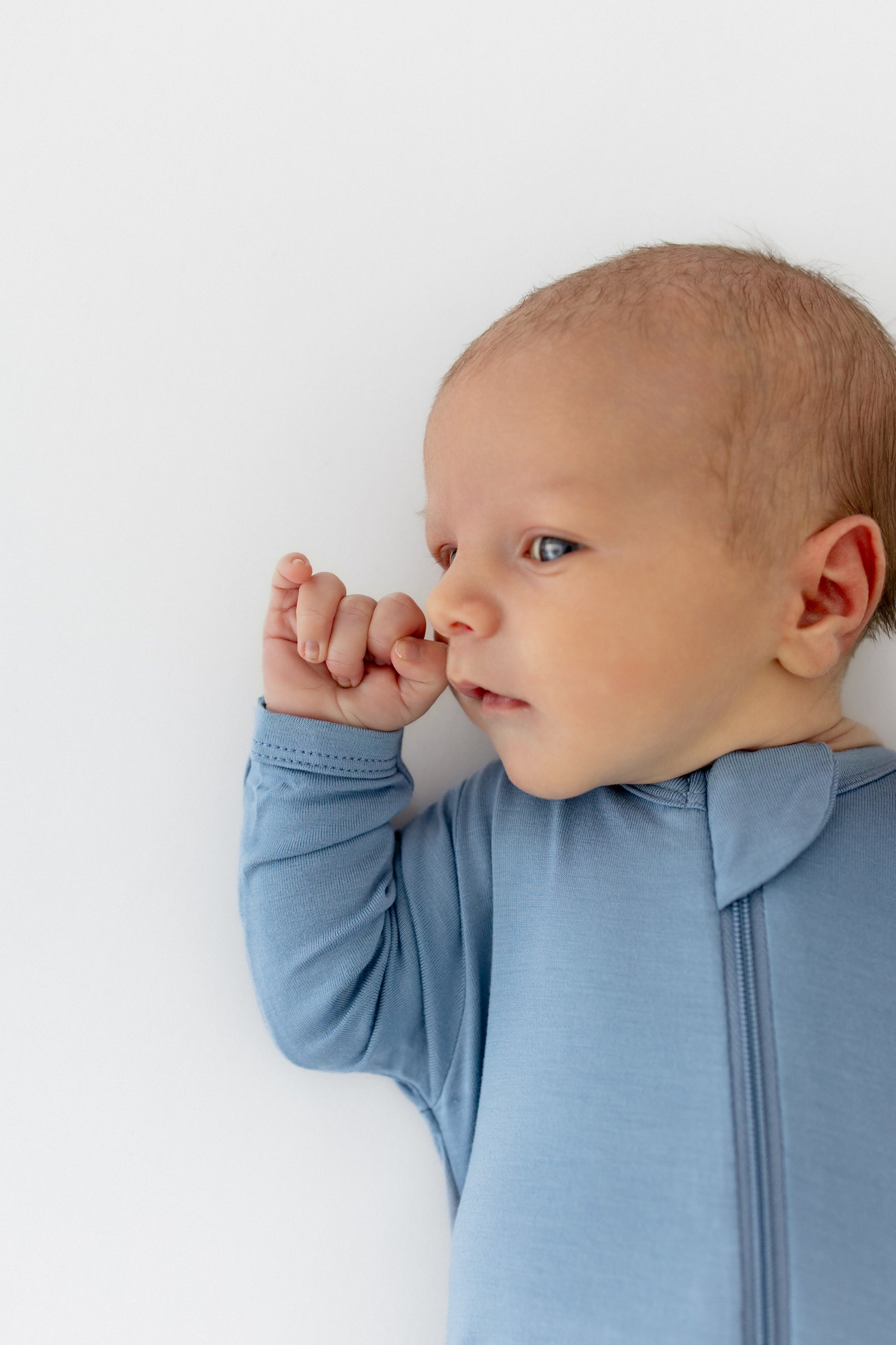 Baby wearing a light blue outfit against a white background