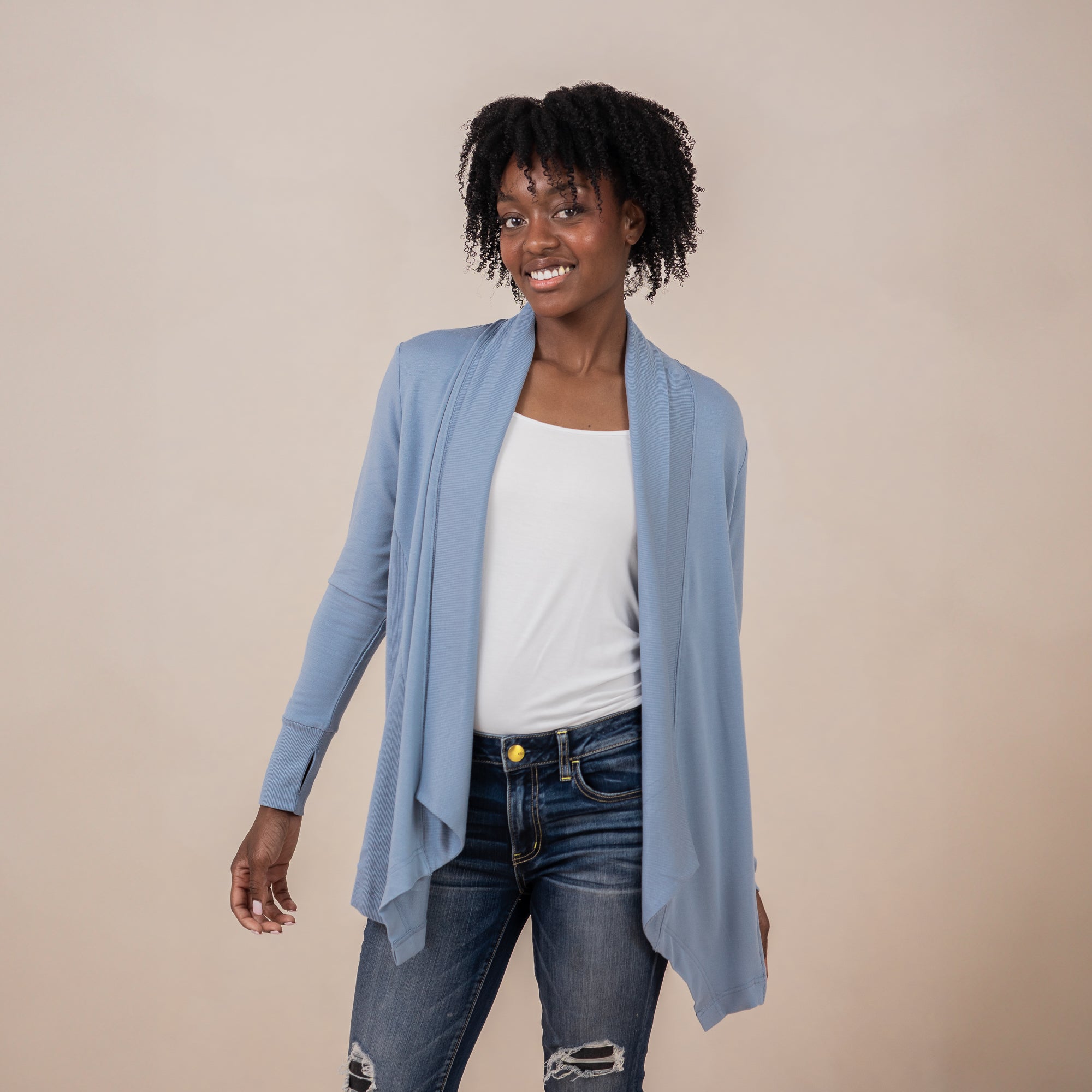 Female model wearing the Women's French Terry Wrap Top in Slate with a white top and dark wash jeans
