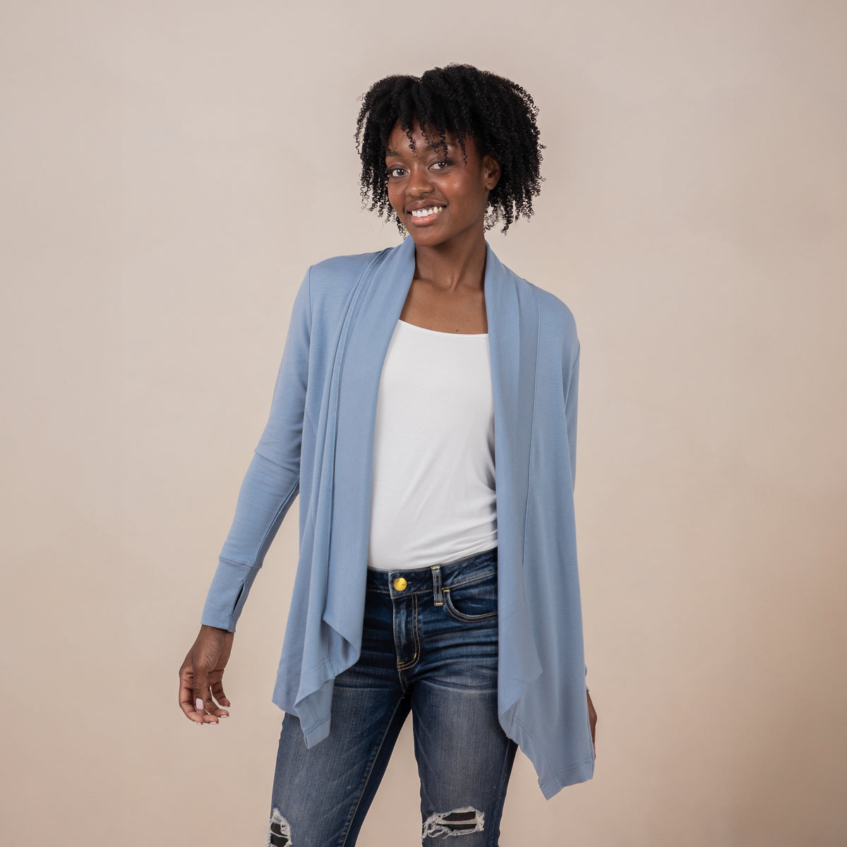 Female model wearing the Women's French Terry Wrap Top in Slate with a white top and dark wash jeans