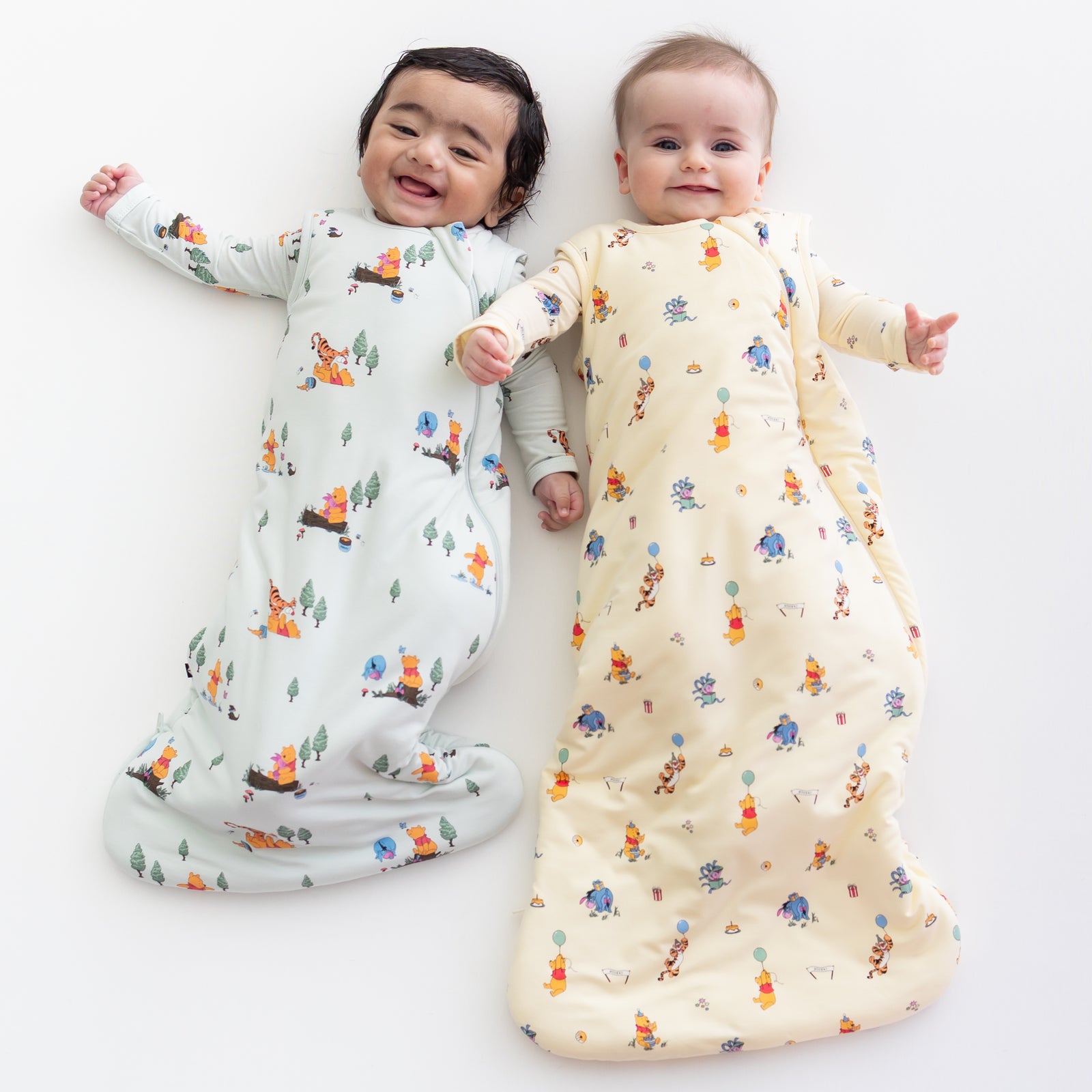 2 babies wearing kyte baby sleep bags in disney's winnie the pooh prints 