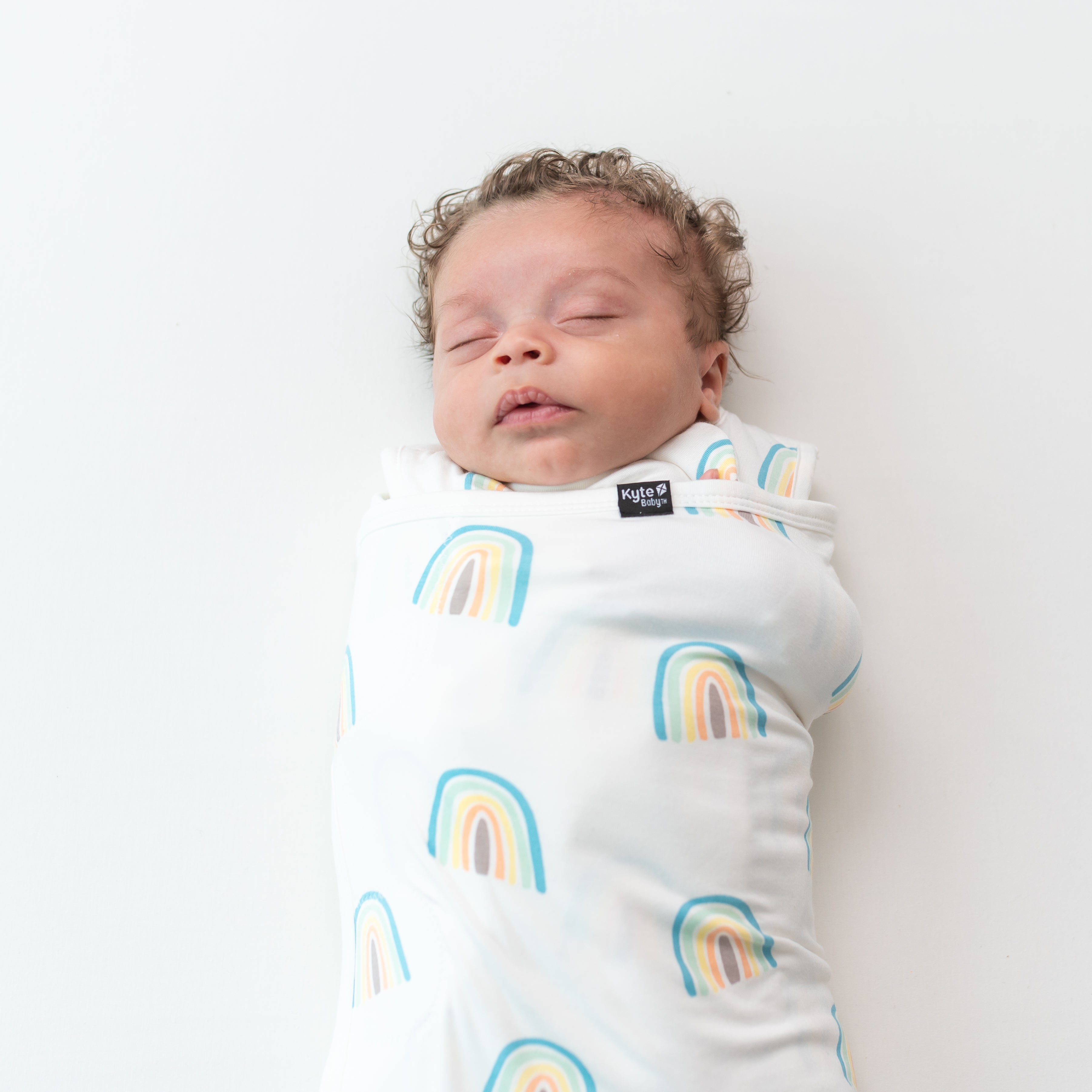 Close up of baby wearing Sleep Bag Swaddler in Makai Rainbow 1.0