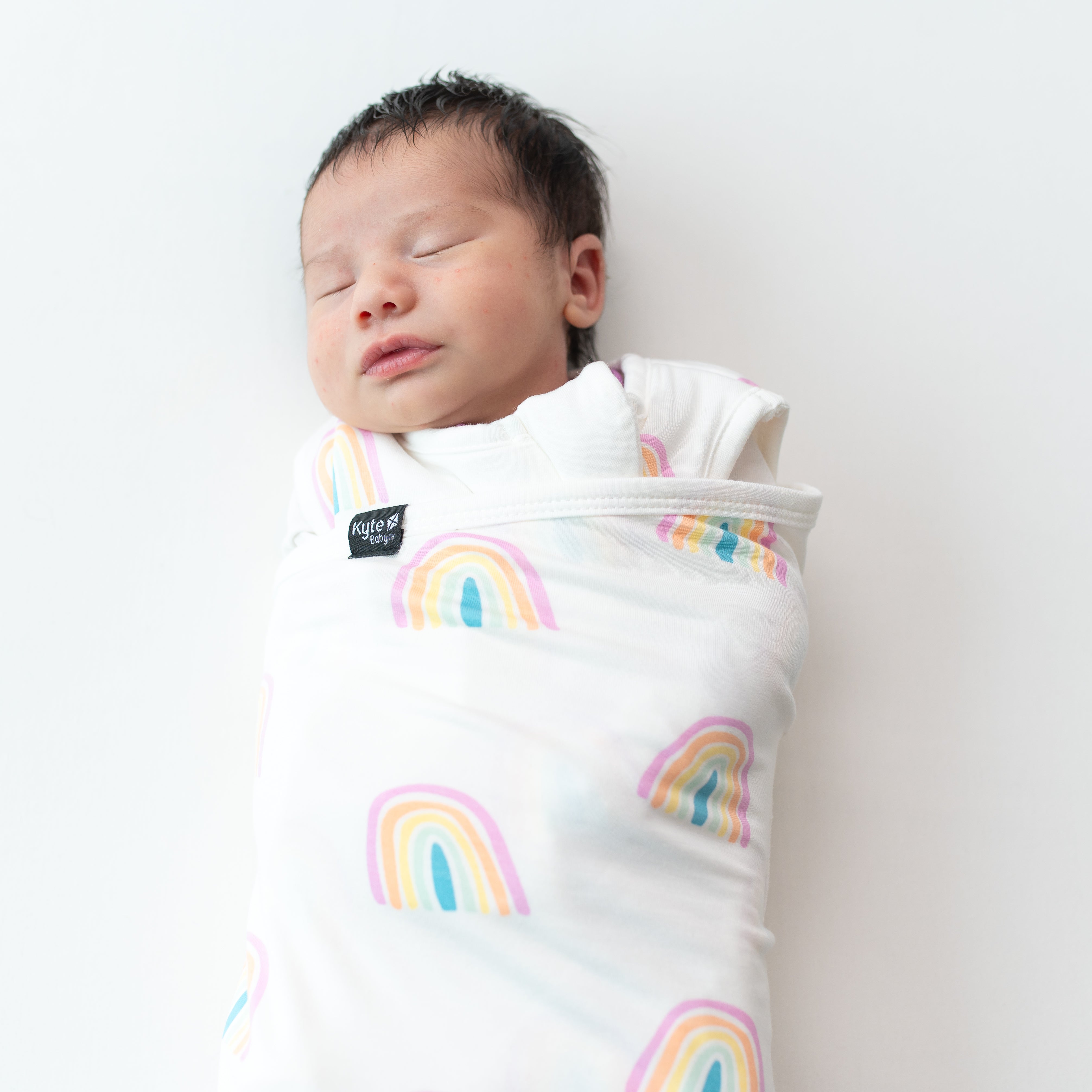 Close up of baby wearing Sleep Bag Swaddler in Poi Rainbow 1.0