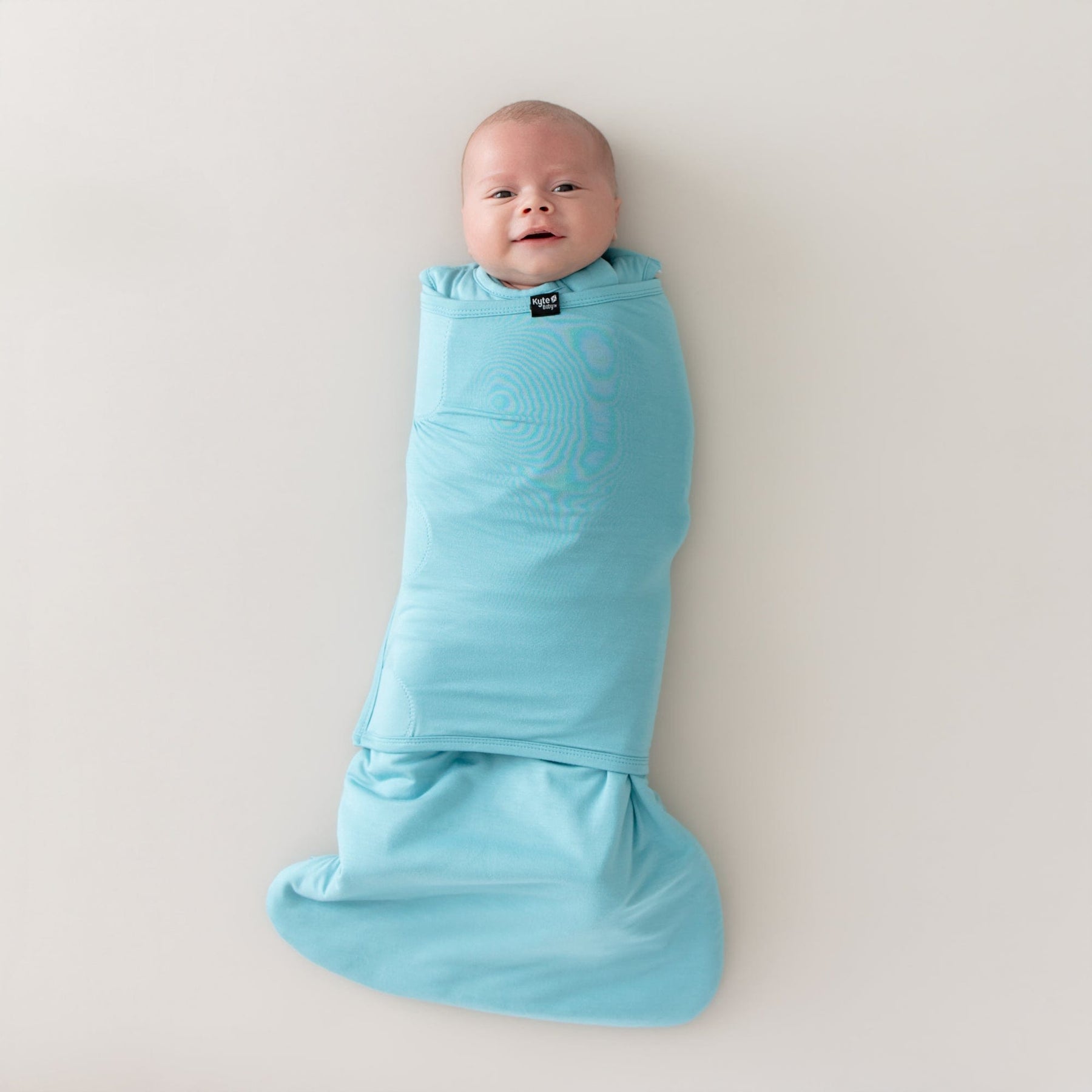 baby wearing sleep bag swaddler in makai