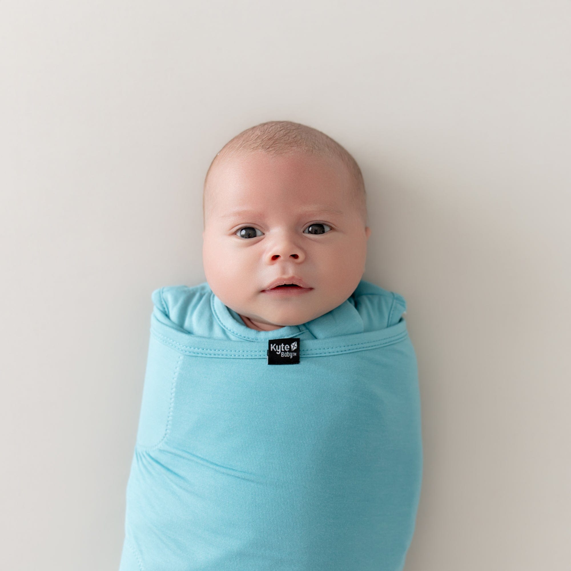 close up of baby wearing sleep bag swaddler in makai