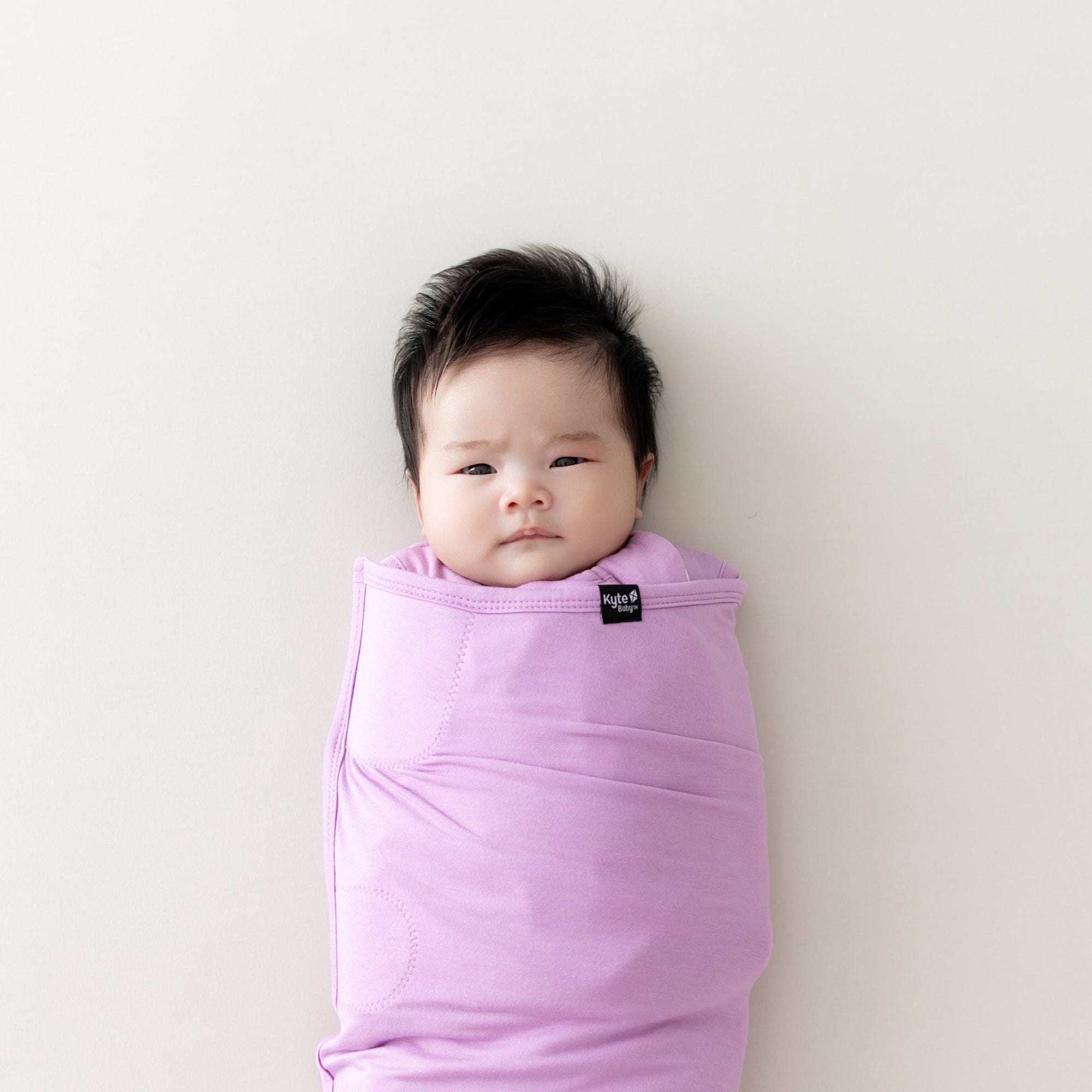 baby wearing sleep bag swaddler in poi from kyte baby