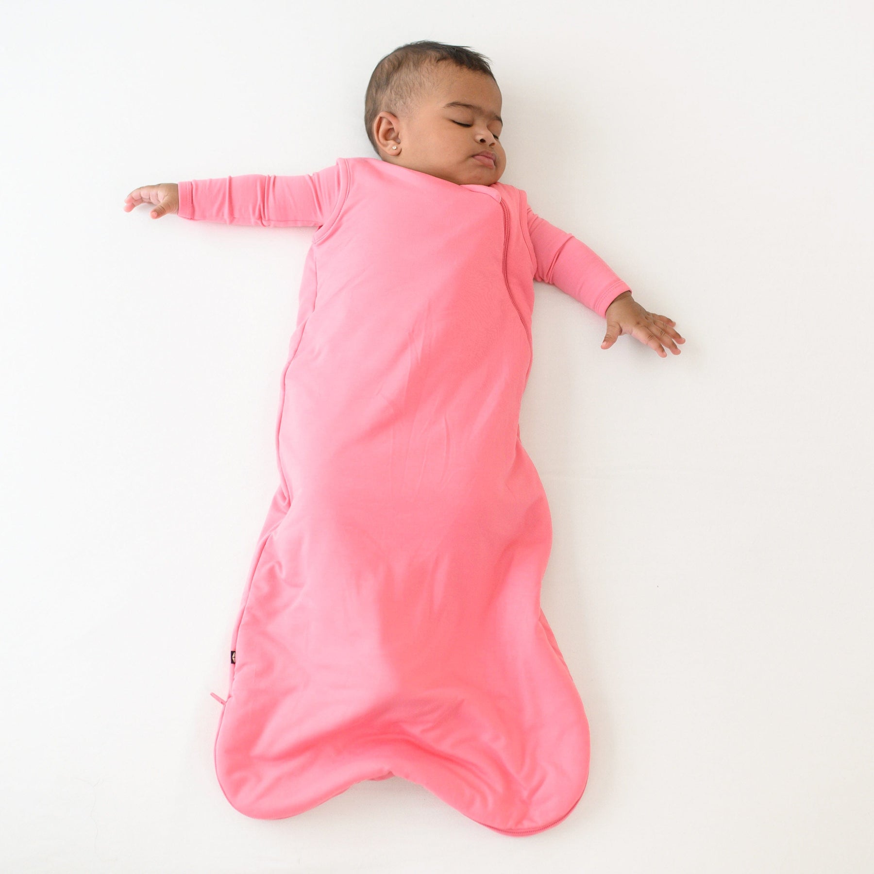 baby asleep wearing sleep bag in guava 