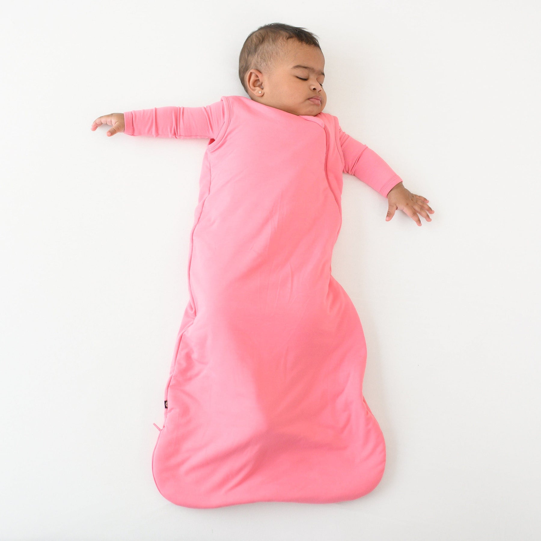 sleeping baby wearing kyte baby sleep bag 1.0 in guava 