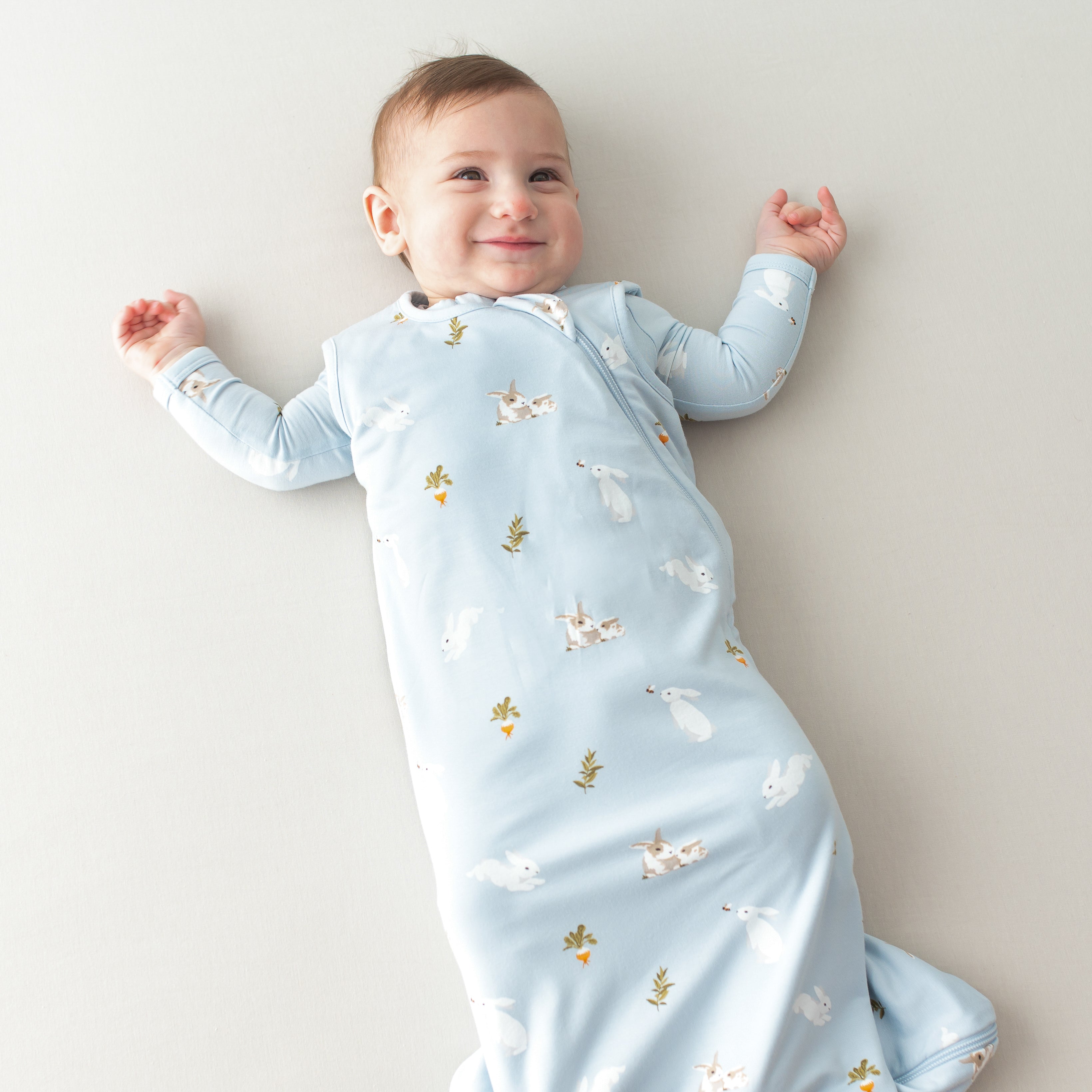 Baby smiling wearing Sleep Bag in Ice Rabbit 0.5