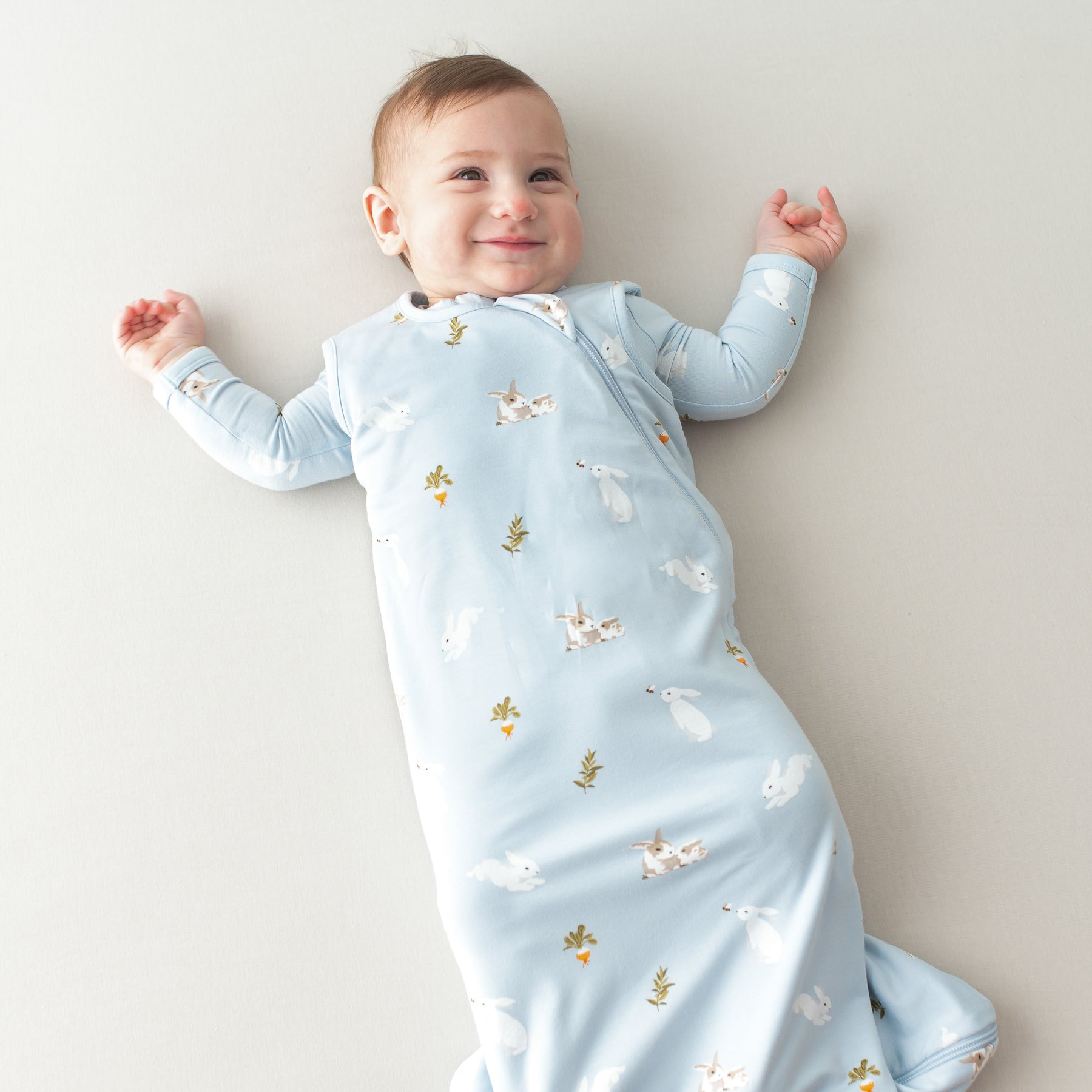 Baby smiling wearing Sleep Bag in Ice Rabbit 0.5