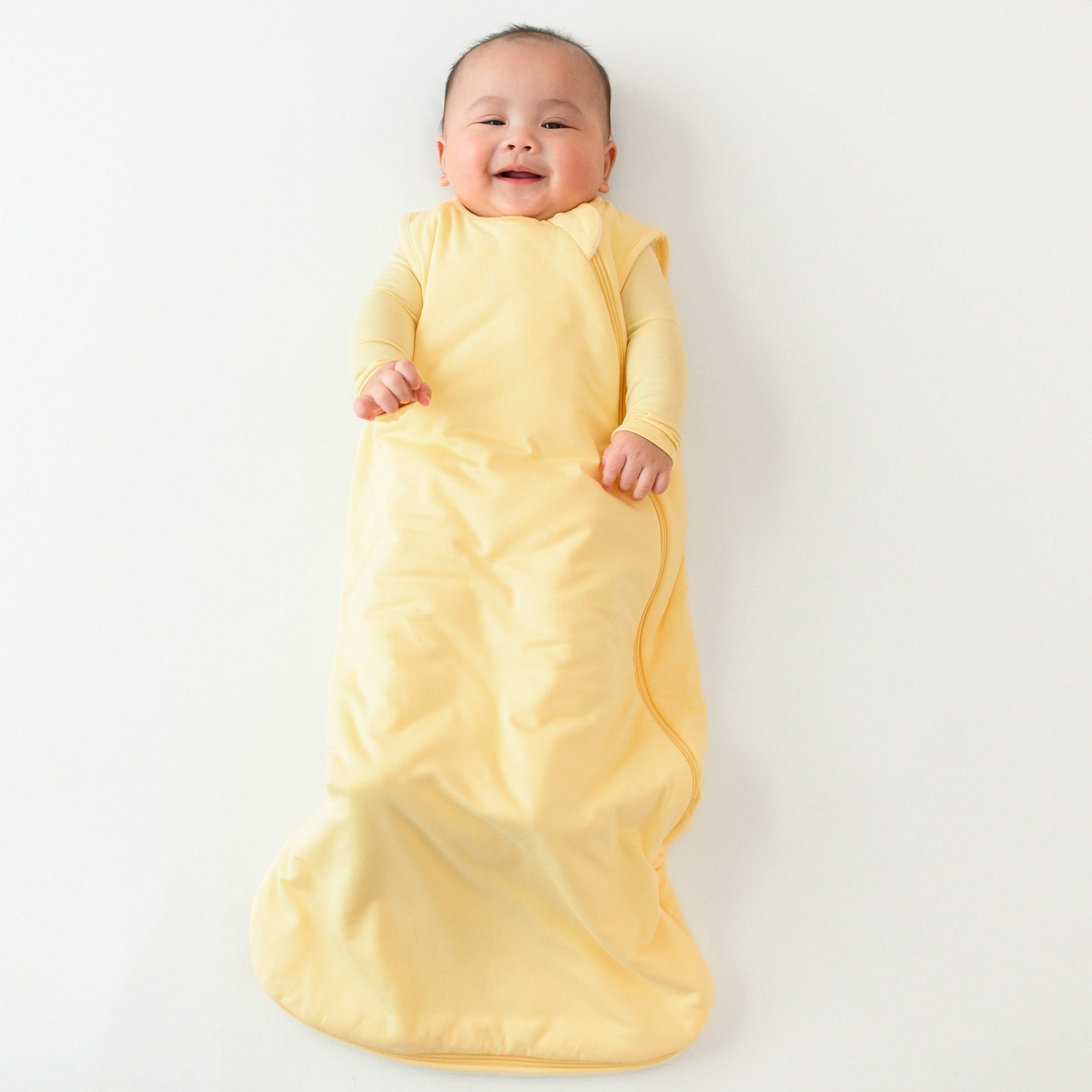 baby smiling while wearing kyte baby 1.0 sleep bag in lilikoi 