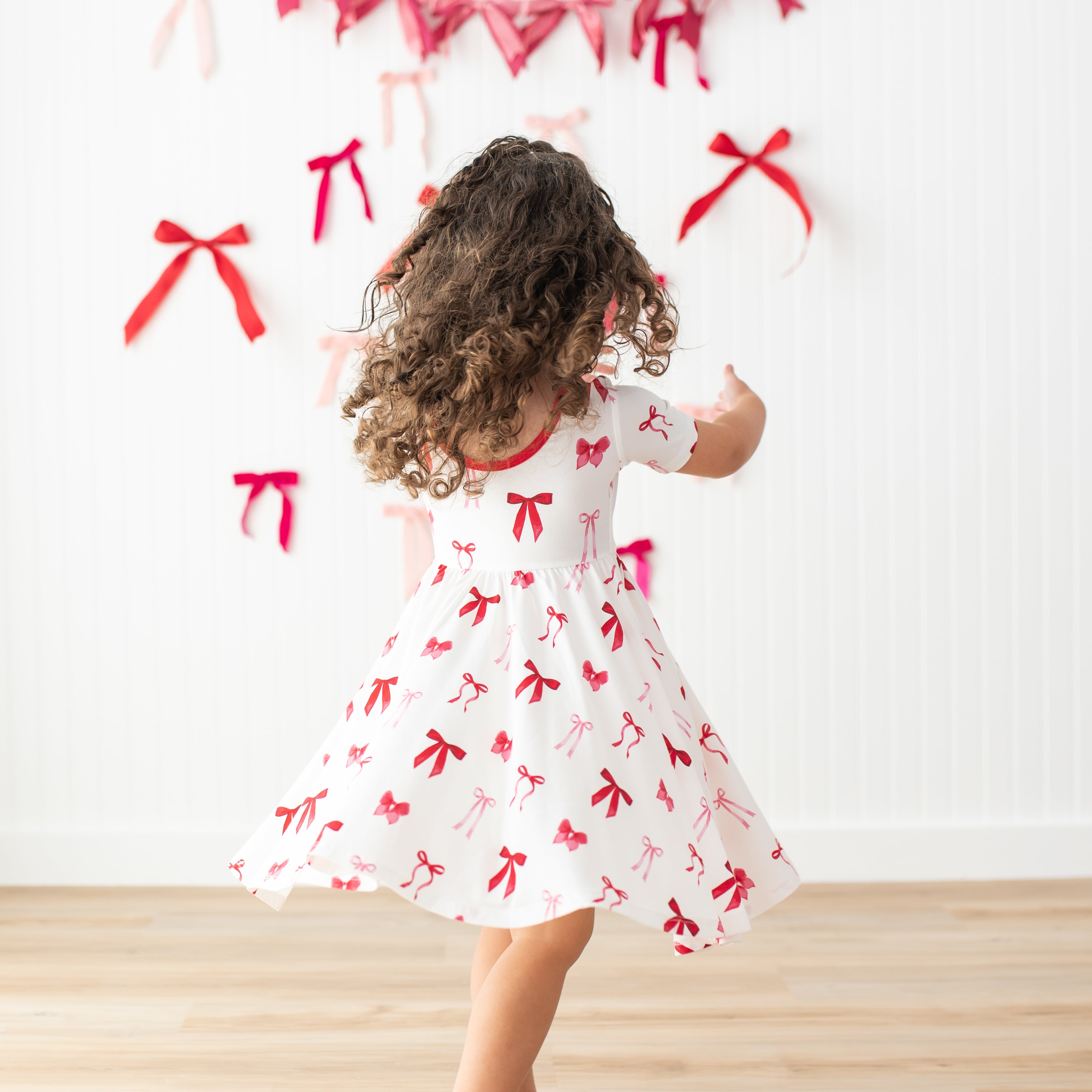 Young girl twirling in her Twirl Dress in Small Love Bow
