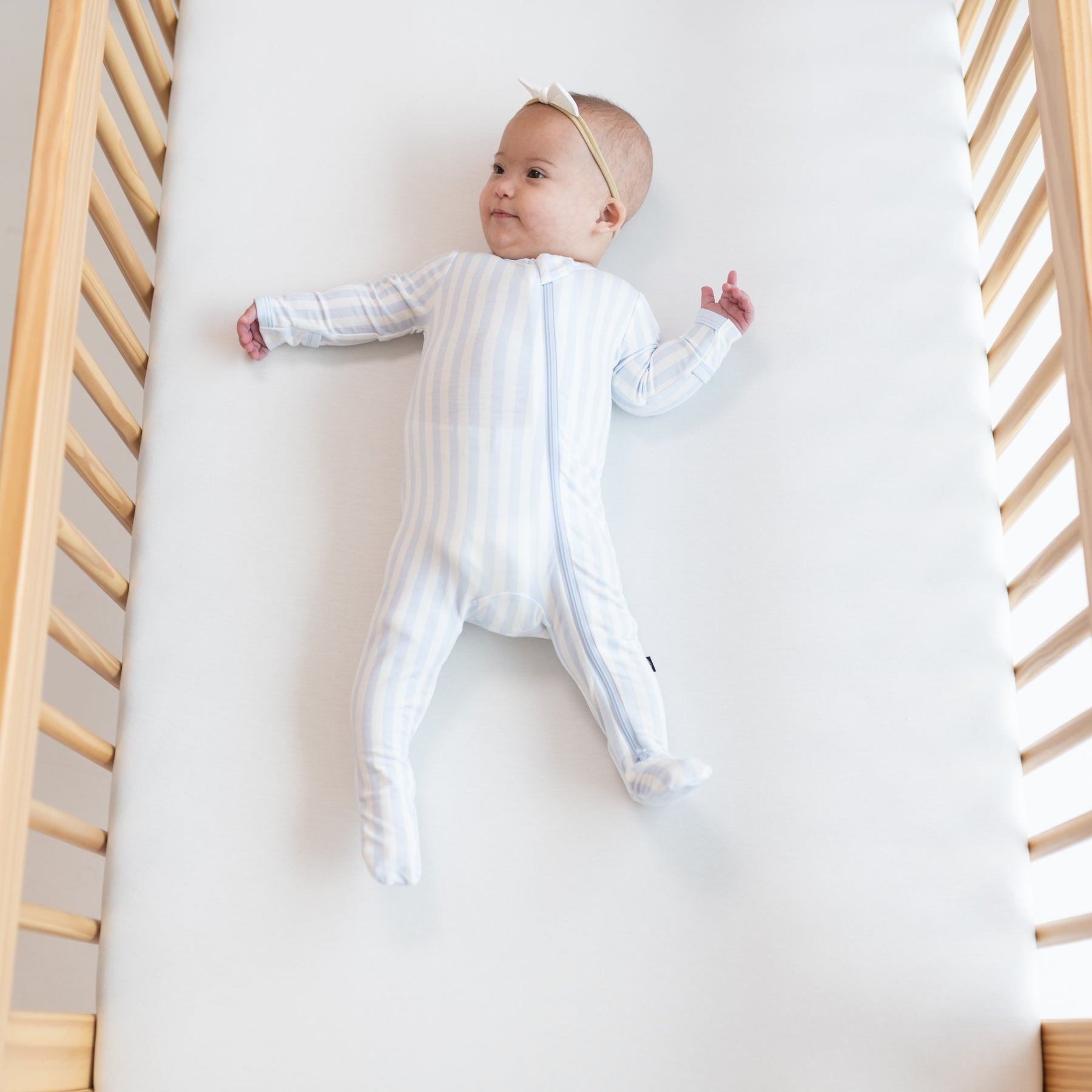 Baby wearing blue and white Zippered Footie in Small Mist Stripe