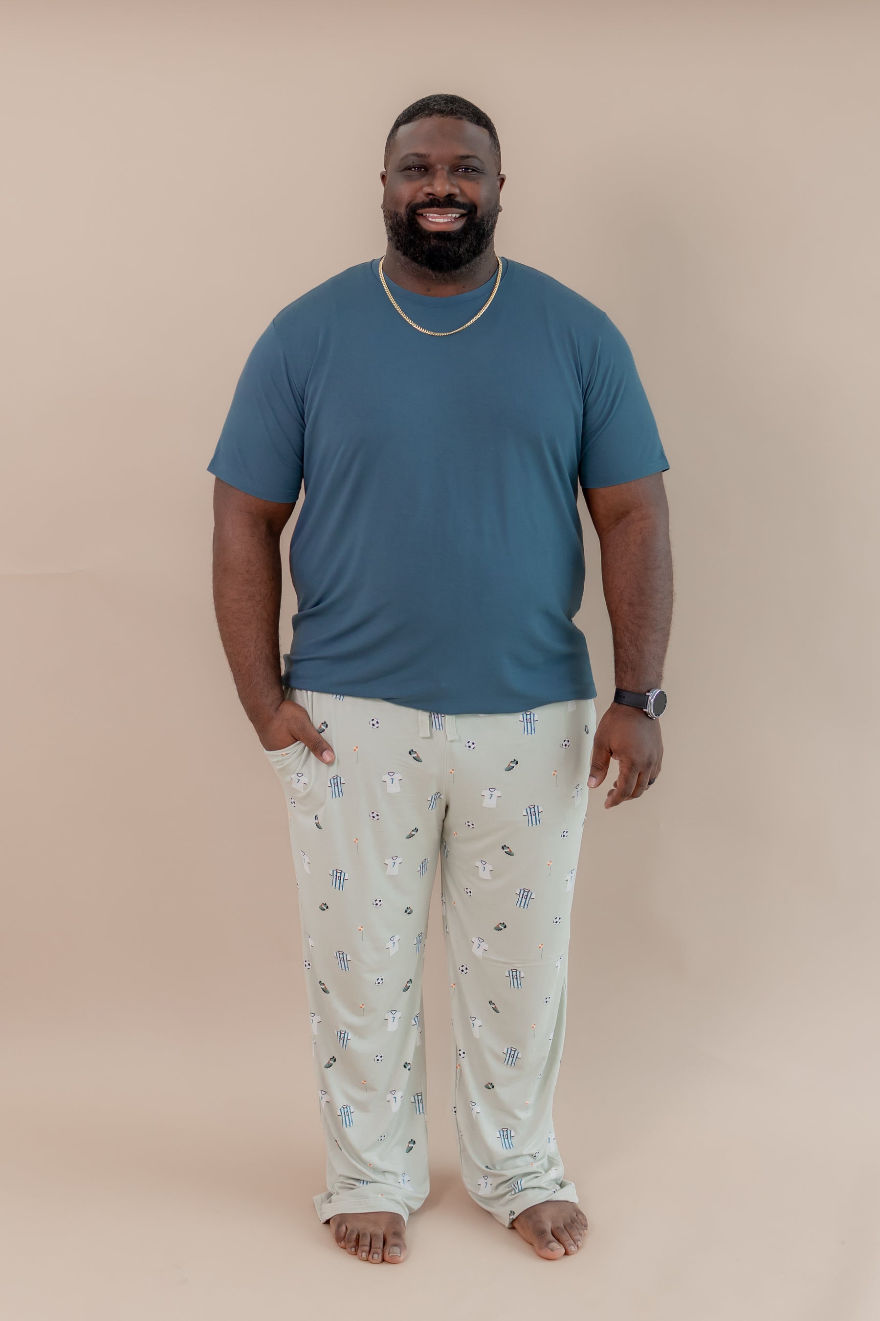 Man posing in Men's Lounge pant in Soccer print under an Atlantic T-shirt on a beige background