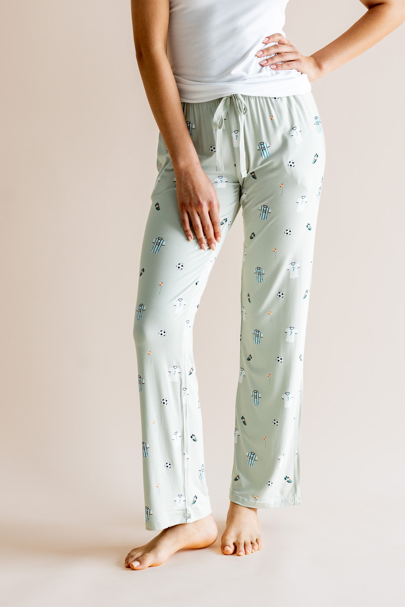 Model wearing Women's Lounge pant with drawstring in Soccer print under white camisole on a beige background