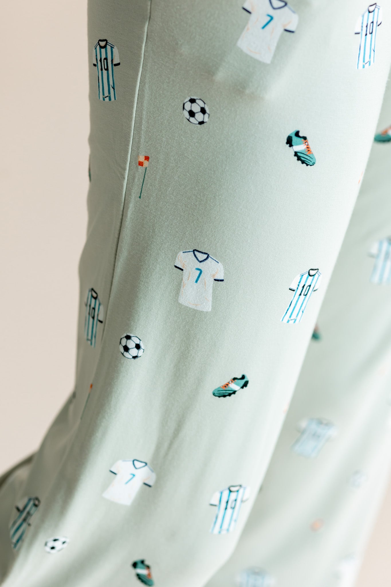 Close up of  Women's Lounge pant in Soccer print on a beige background
