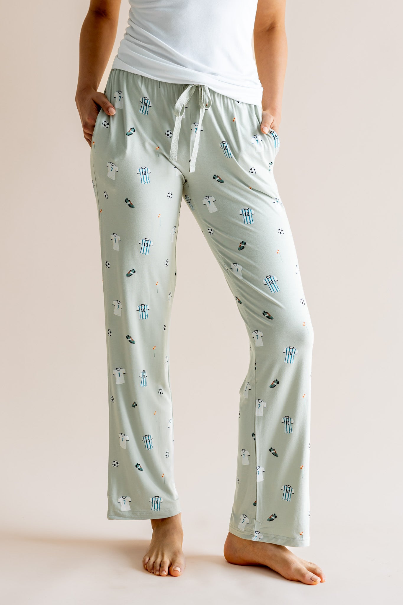 Model wearing Women's Lounge pant with pockets in Soccer print under white camisole on a beige background