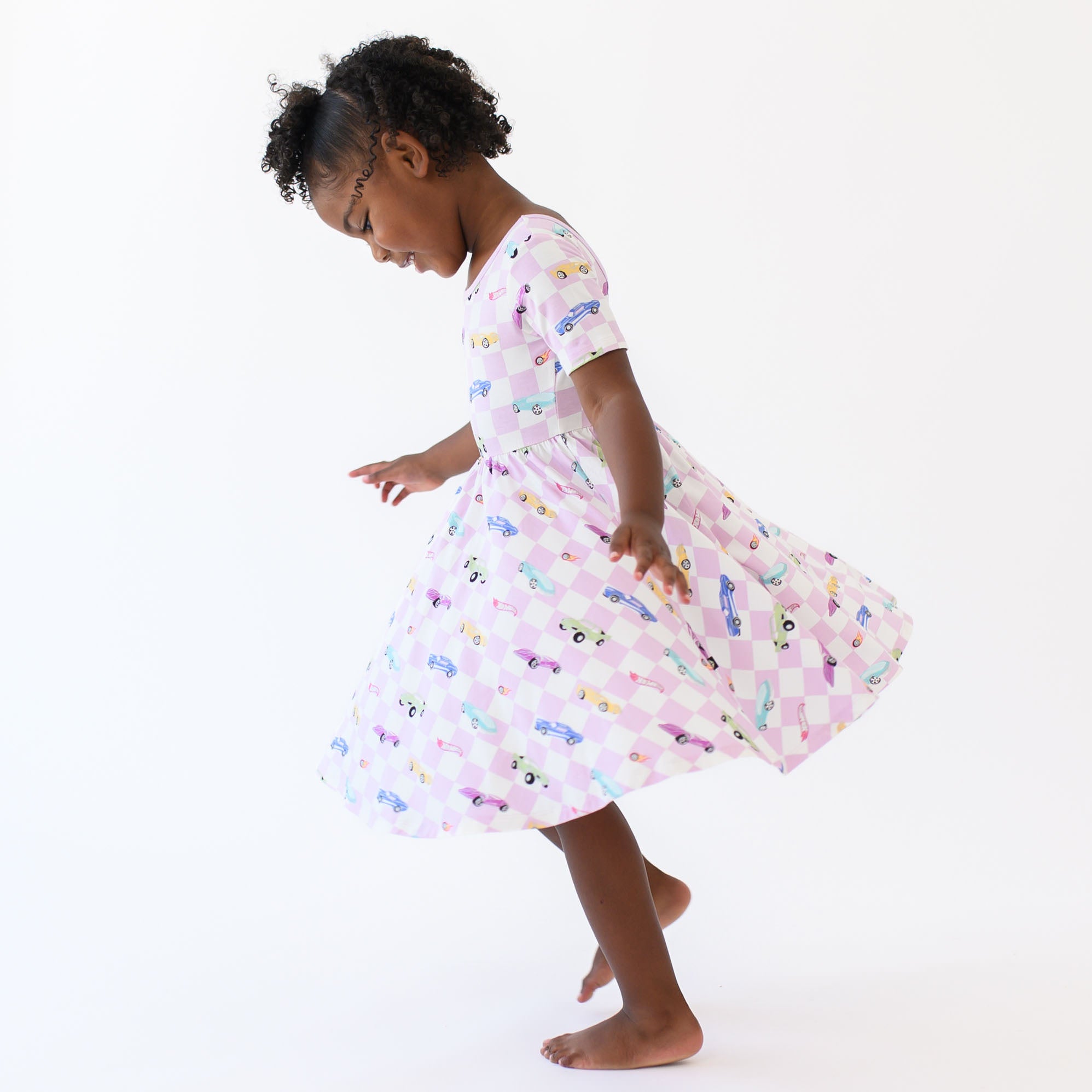 Young girl twirling in the Twirl Dress in Sparkles and Speed