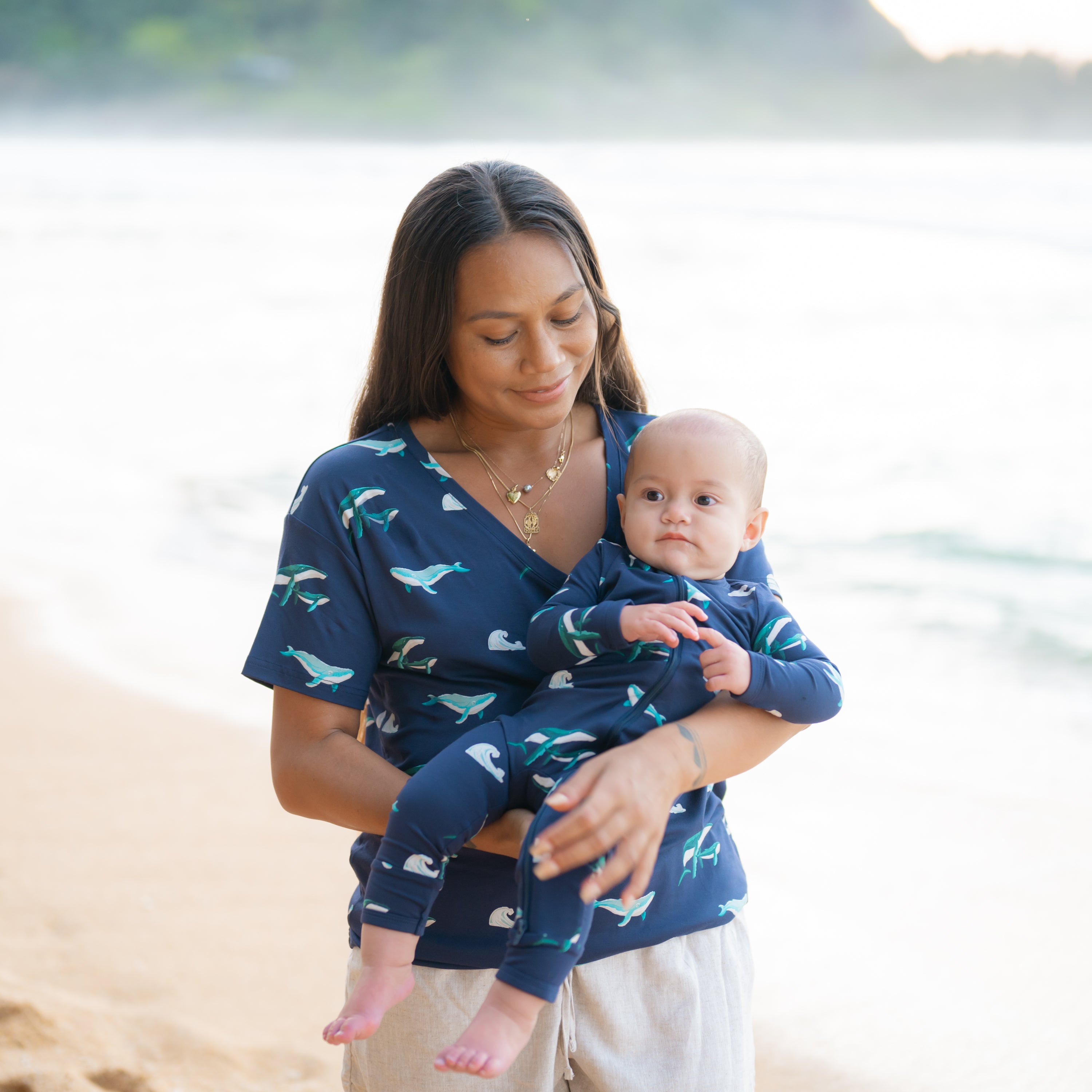 mom in Women’s Relaxed Fit V-Neck in Humpback holding baby in Humpback romper