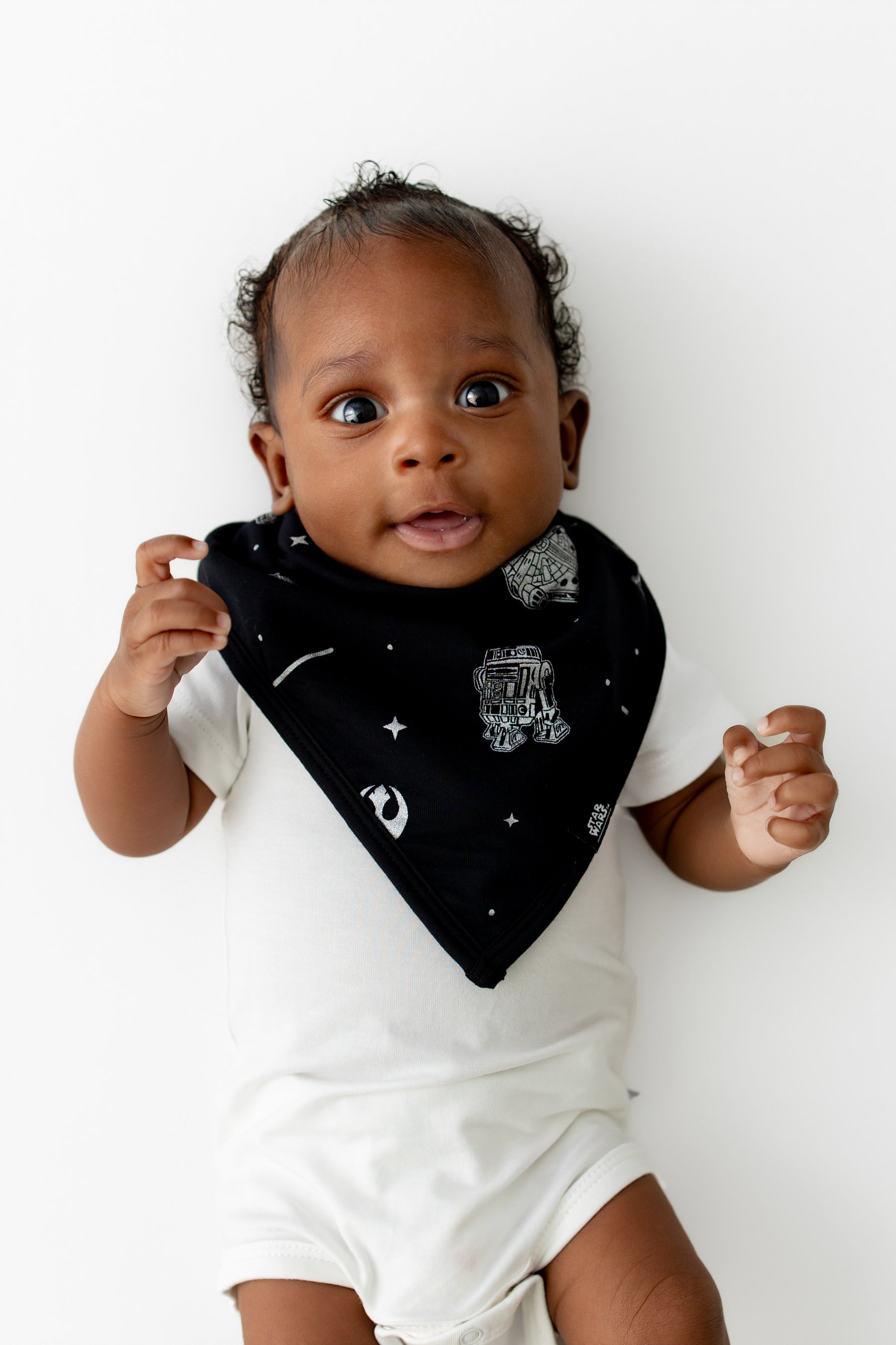 Infant wearing the Bib in STAR WARS™ overtop a short sleeve white bodysuit