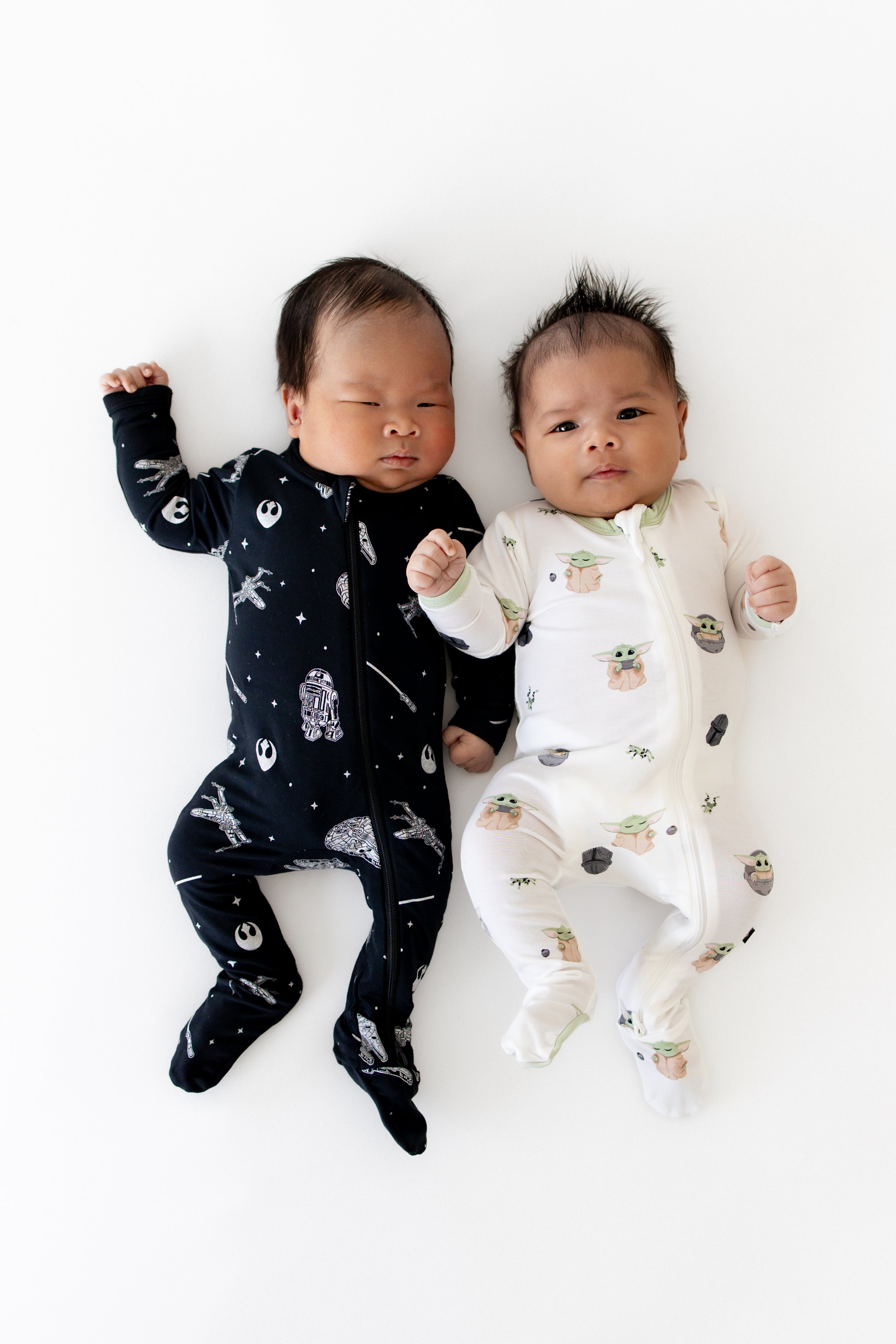 Two newborns laying side by side wearing the Zippered Footie in STAR WARS™ and Grogu™