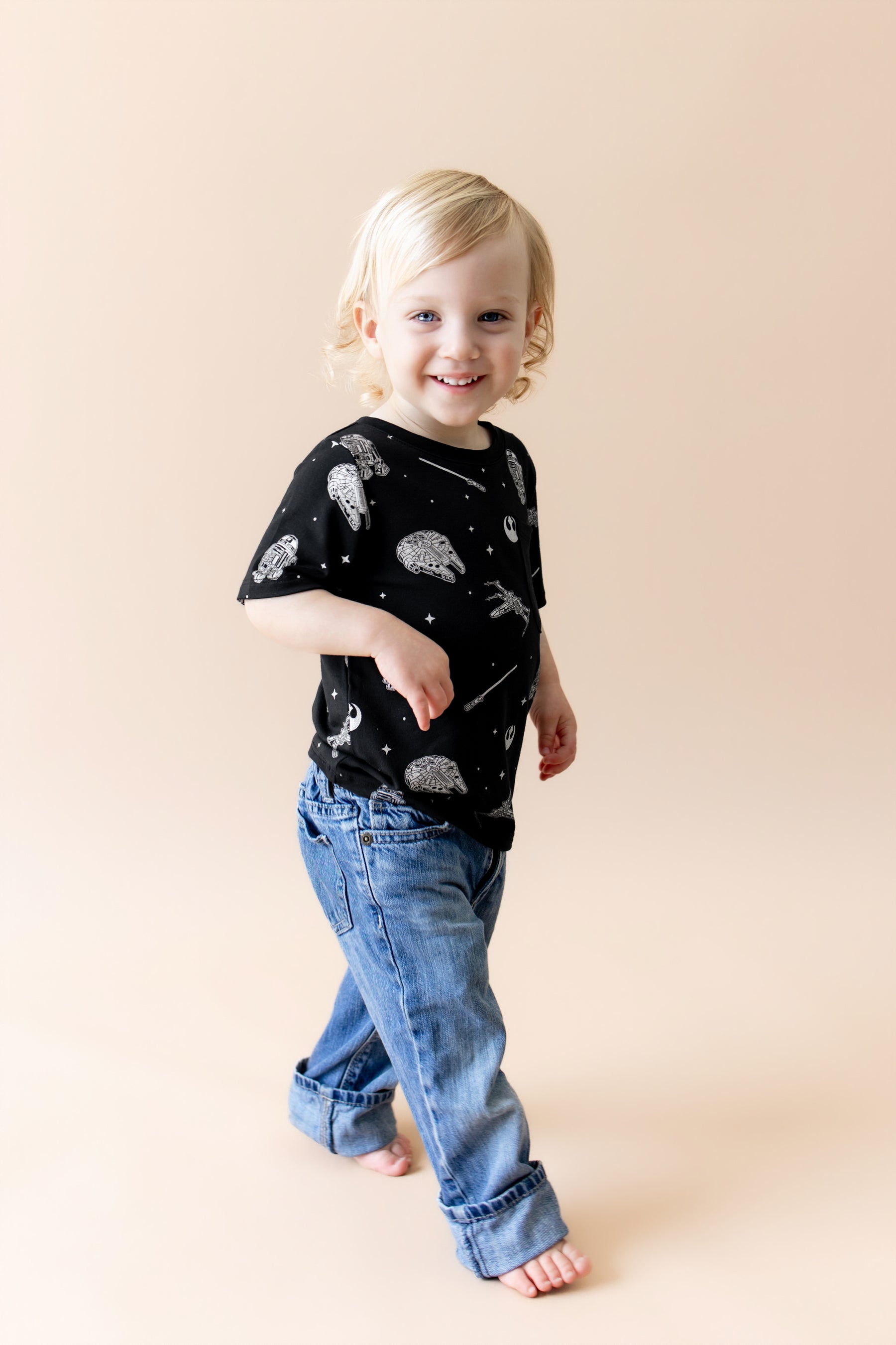 Young child walking wearing the Toddler Crew Neck Tee in STAR WARS™ with medium wash jeans