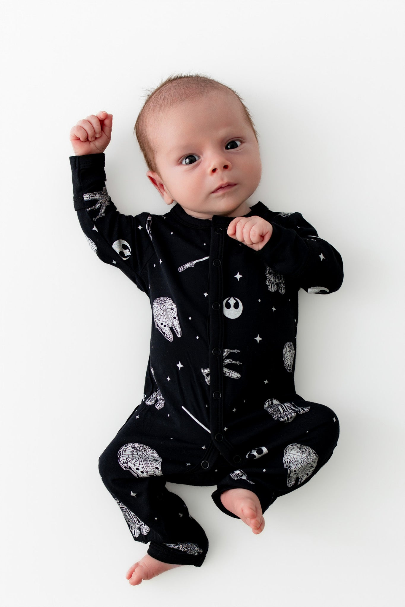 Infant laying on a white surface wearing the Romper in STAR WARS™