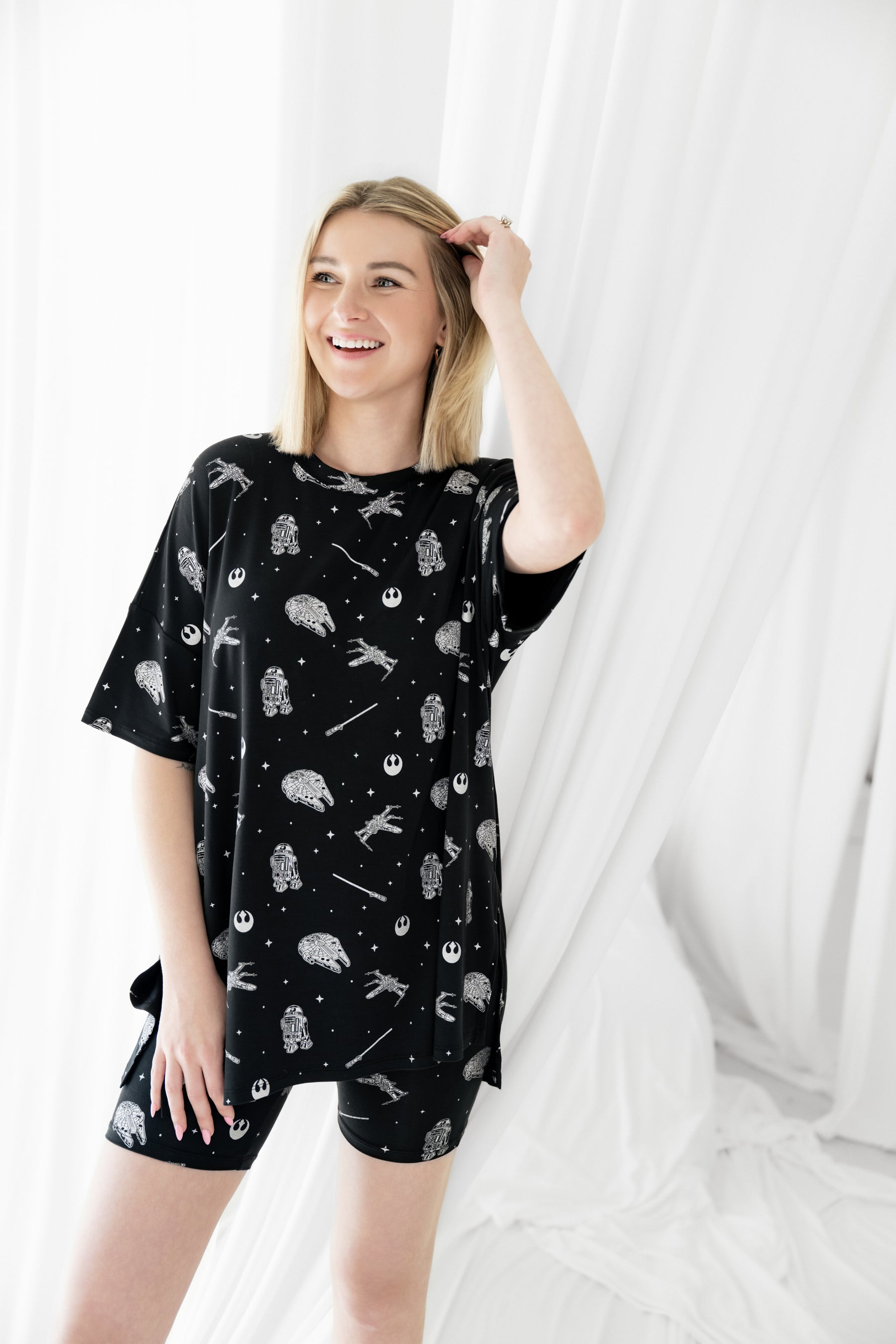 Smiling female posing wearing the Women’s Biker Short Set in STAR WARS™ in front of a white background