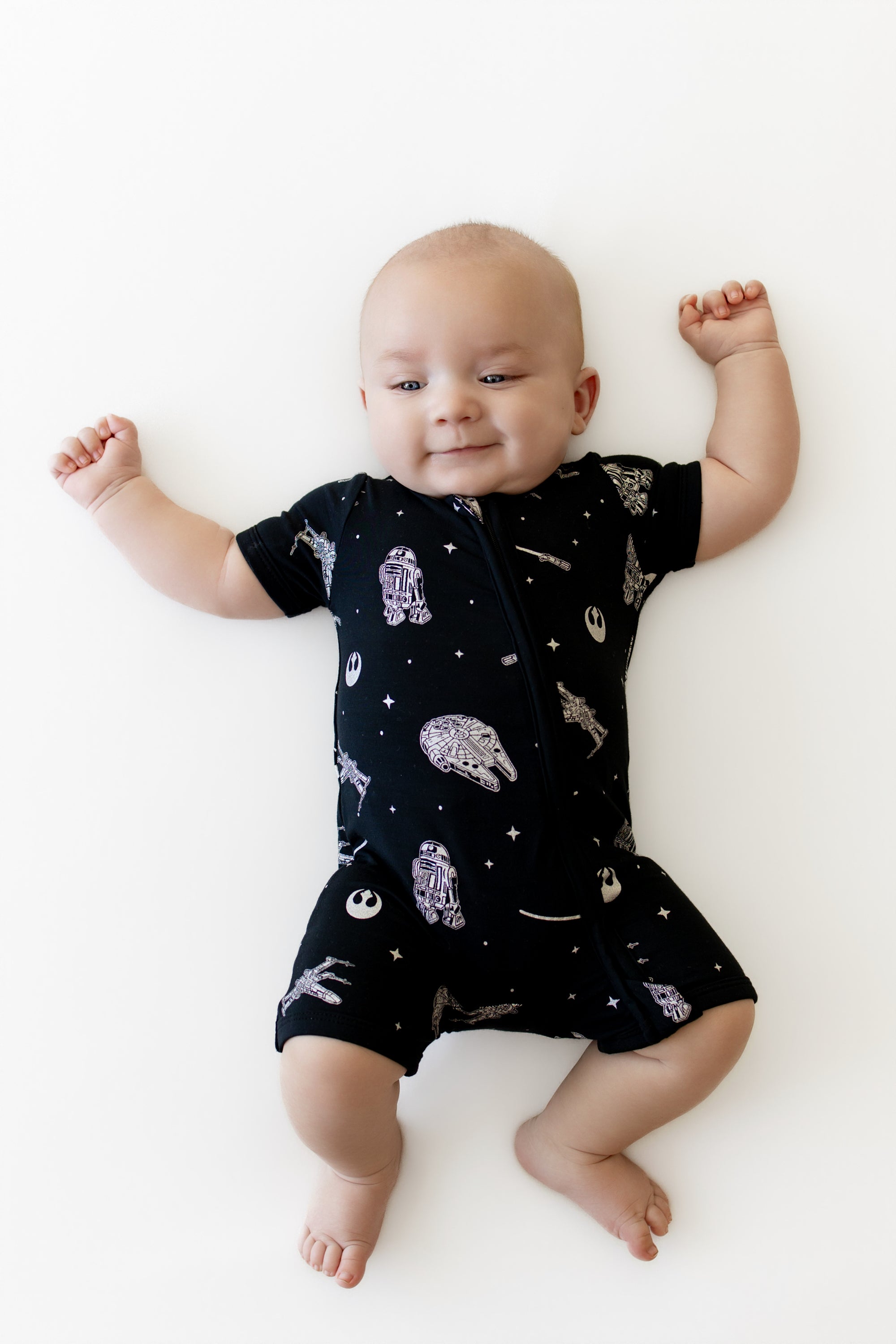 Close up of smiling infant wearing the Zipper Shortall Romper in STAR WARS™