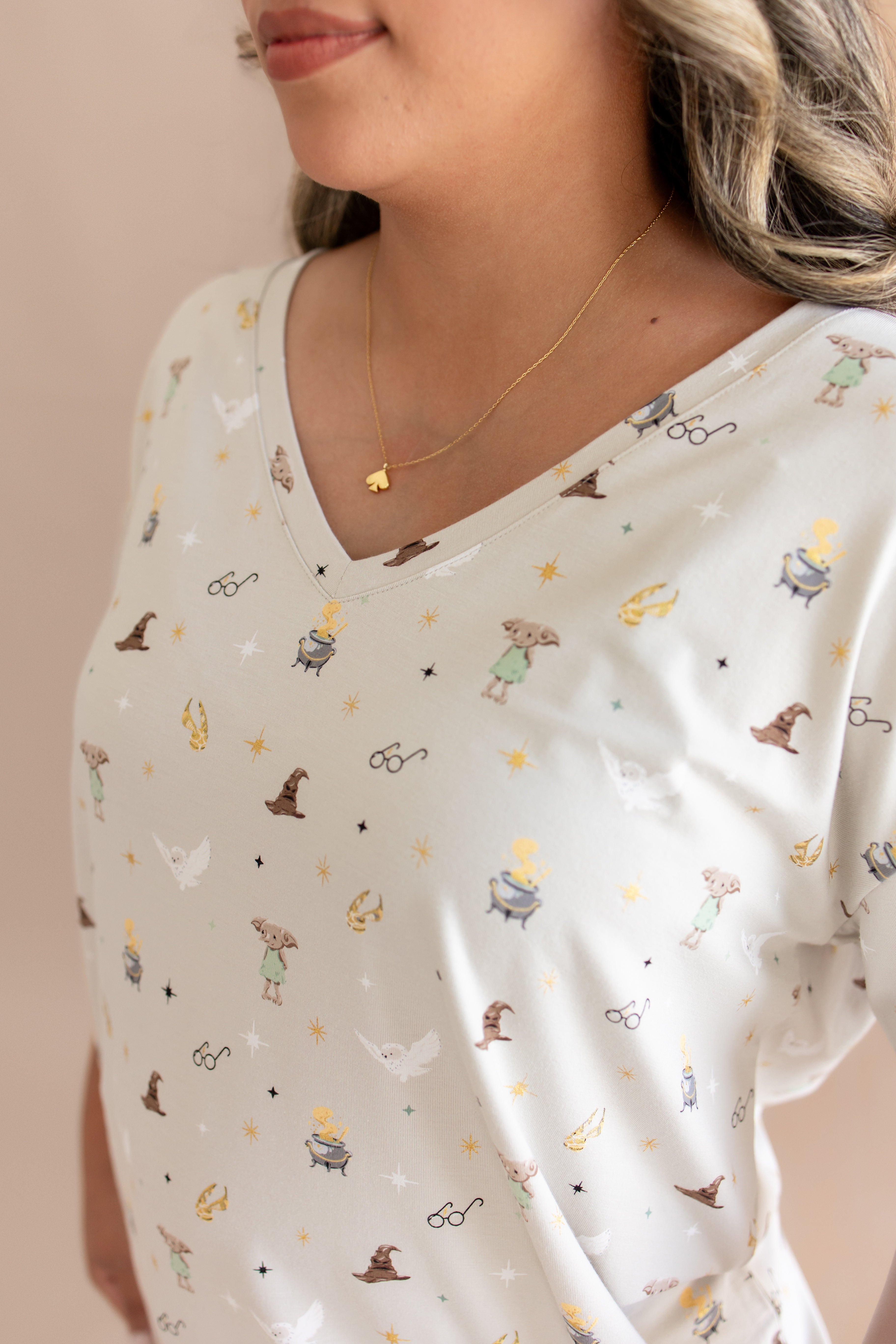 Neck of model wearing Women's Relaxed Fit V-Neck with Harry Potter prints on a beige background