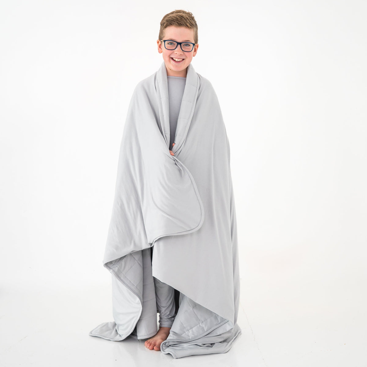 Child wrapped in a light grey bamboo blanket