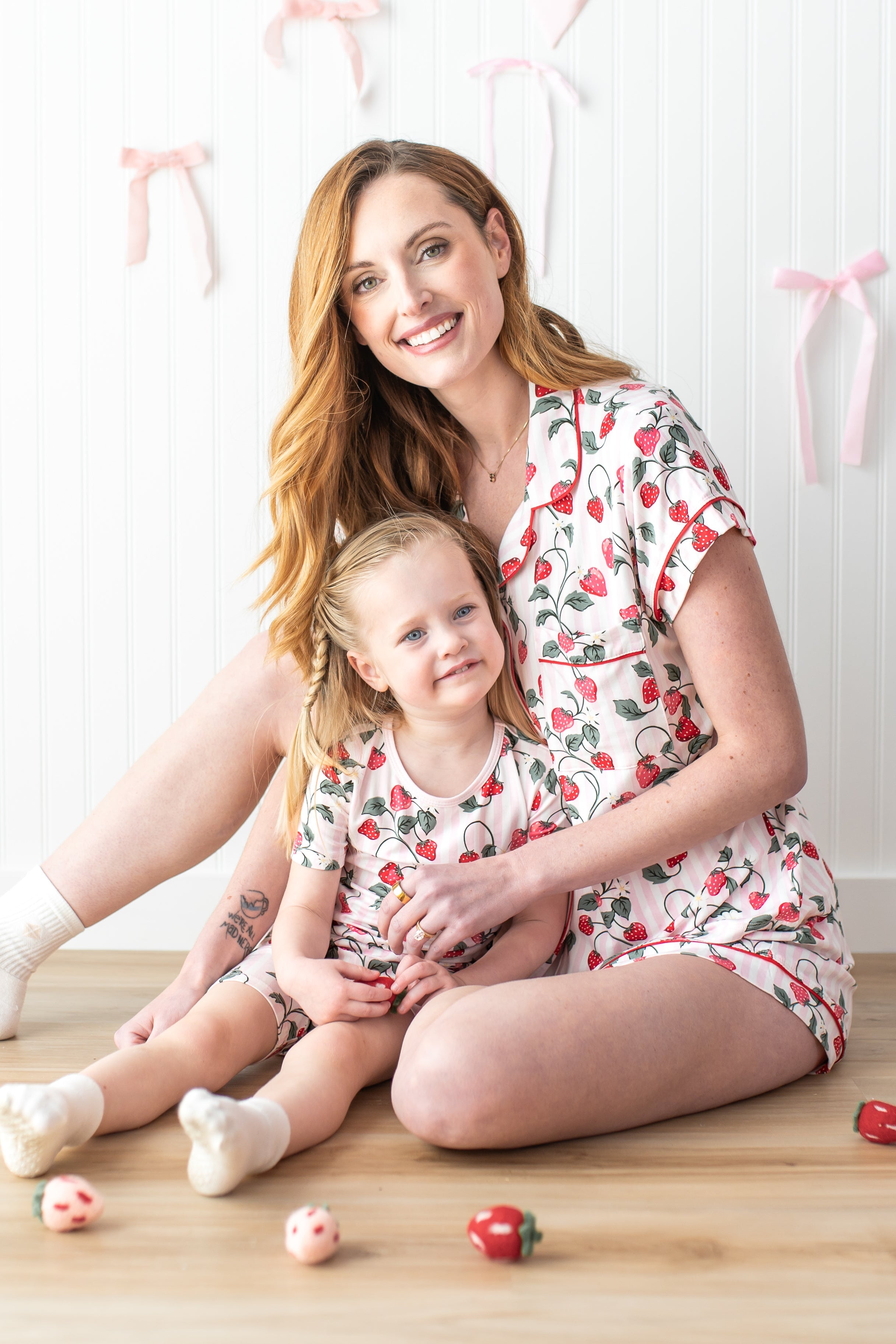 Mother and daughter sitting on the floor matching in Strawberry Fields matching pajamas
