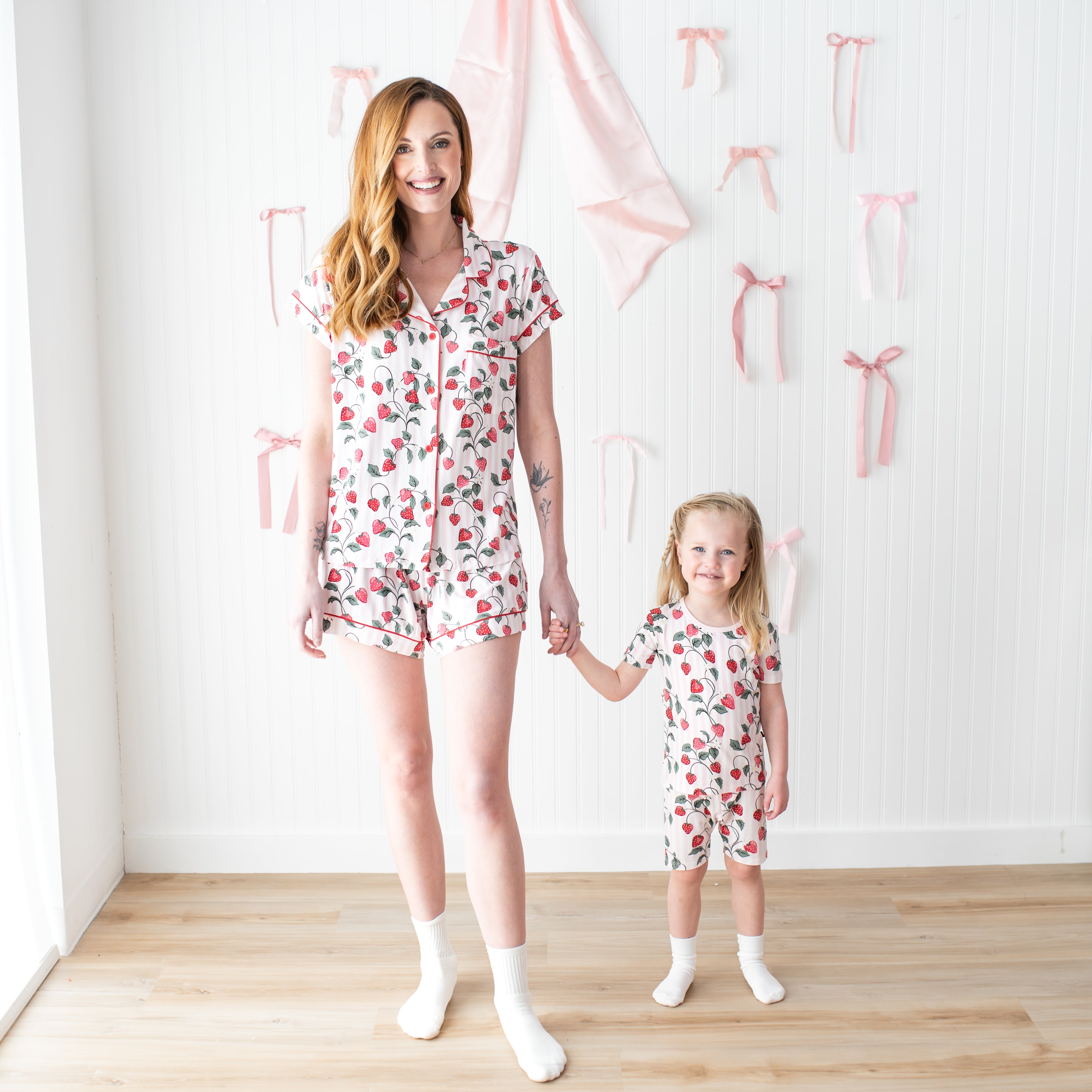 Mother and daughter holding hands wearing matching pajamas in  Strawberry Fields