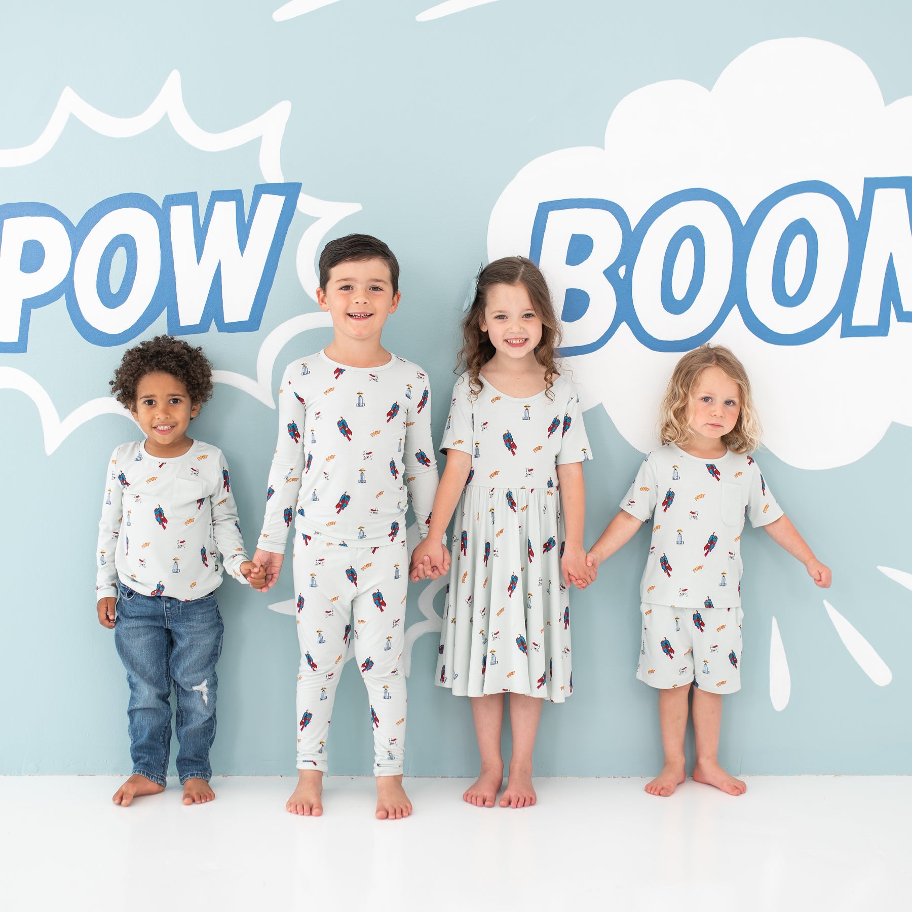 Four children models standing holding hands wearing various items from the Superman™ collection