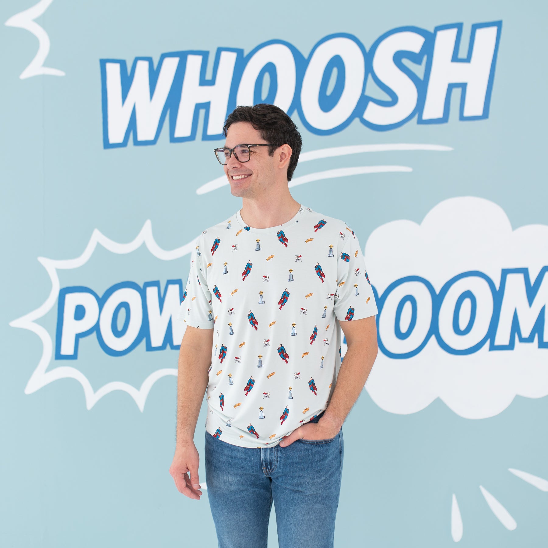 Smiling male model looking off to the side with hand in his jean pocket wearing the Men's Crew Neck Tee in Superman™