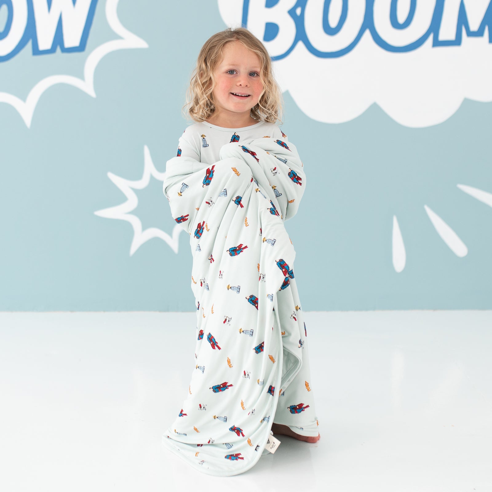 Child wrapped in Superman™ Toddler Blanket in 1.0 TOG