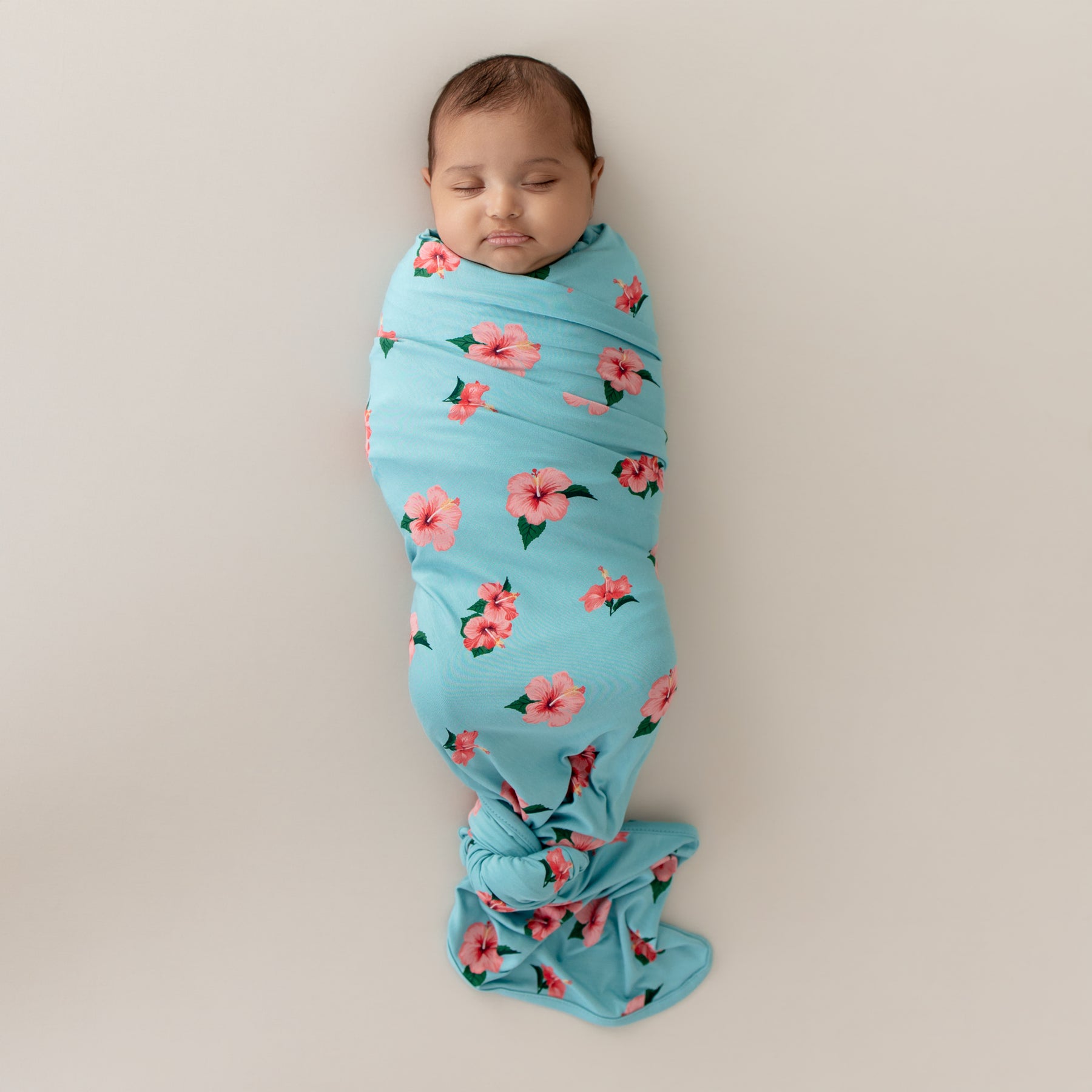 Baby swaddled in Kyte Swaddle Blanket in Hibiscus