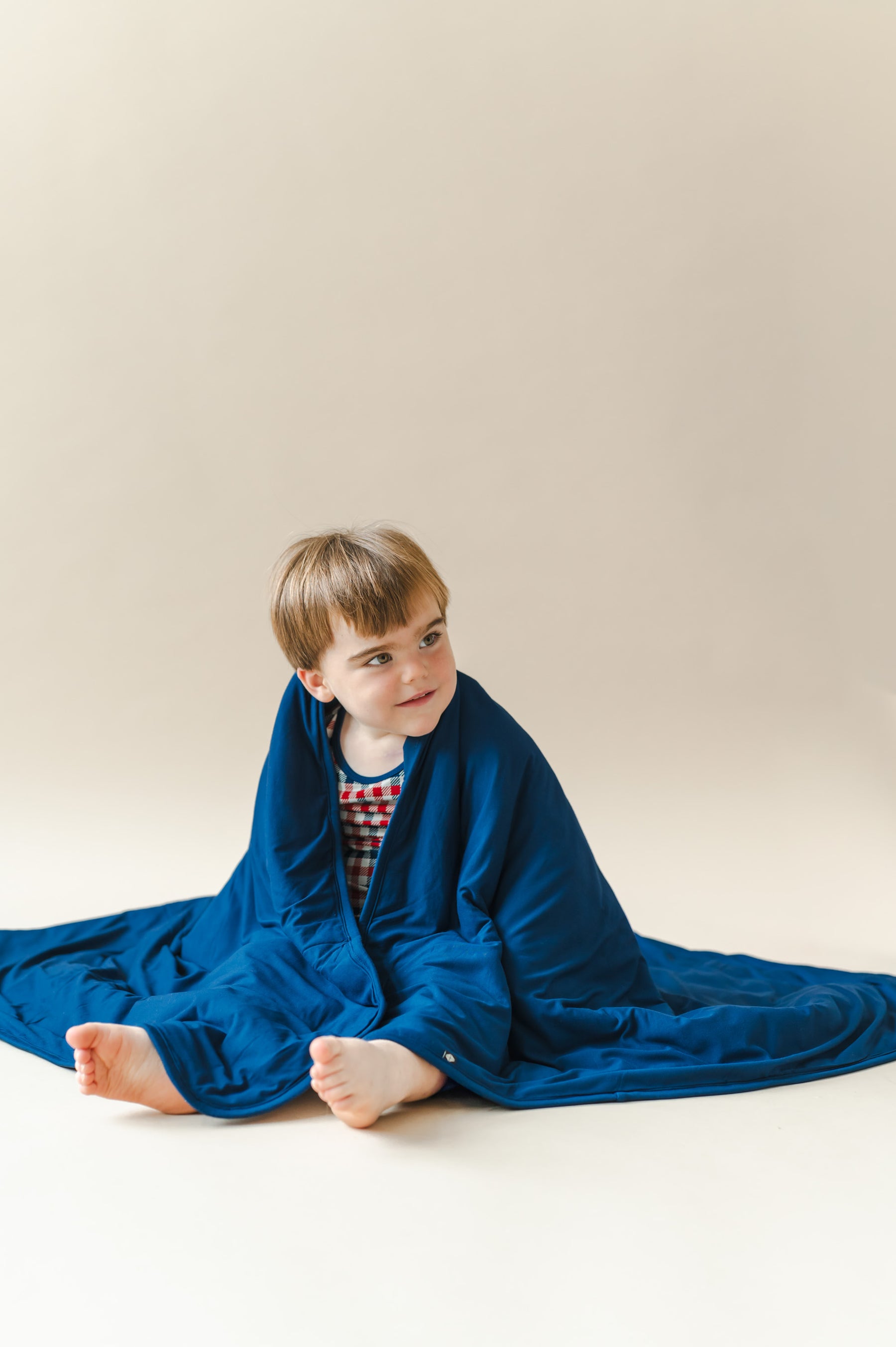 Child wrapped in Toddler Blanket in Tahoe on a beige background