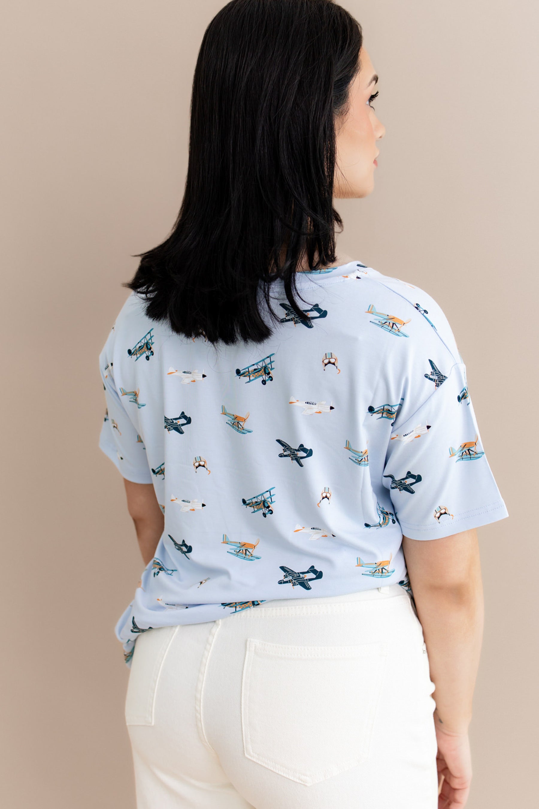 The back of the Women's Relaxed Fit V-Neck in Take Off shown on a model paired with cream pants