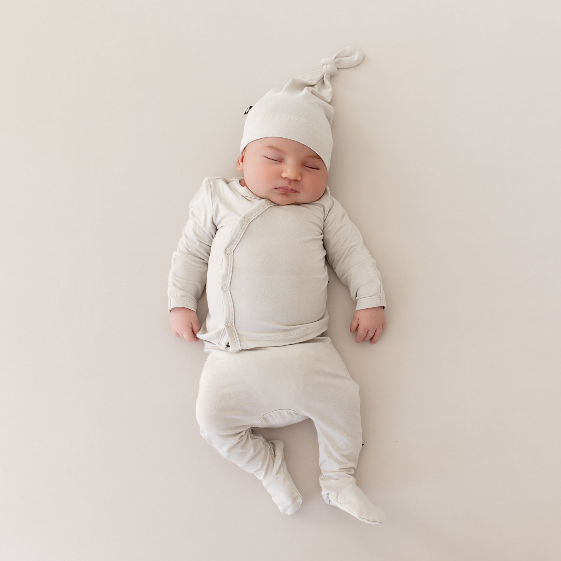 Baby sleeping in Take Me Home Set with Cap in Oat