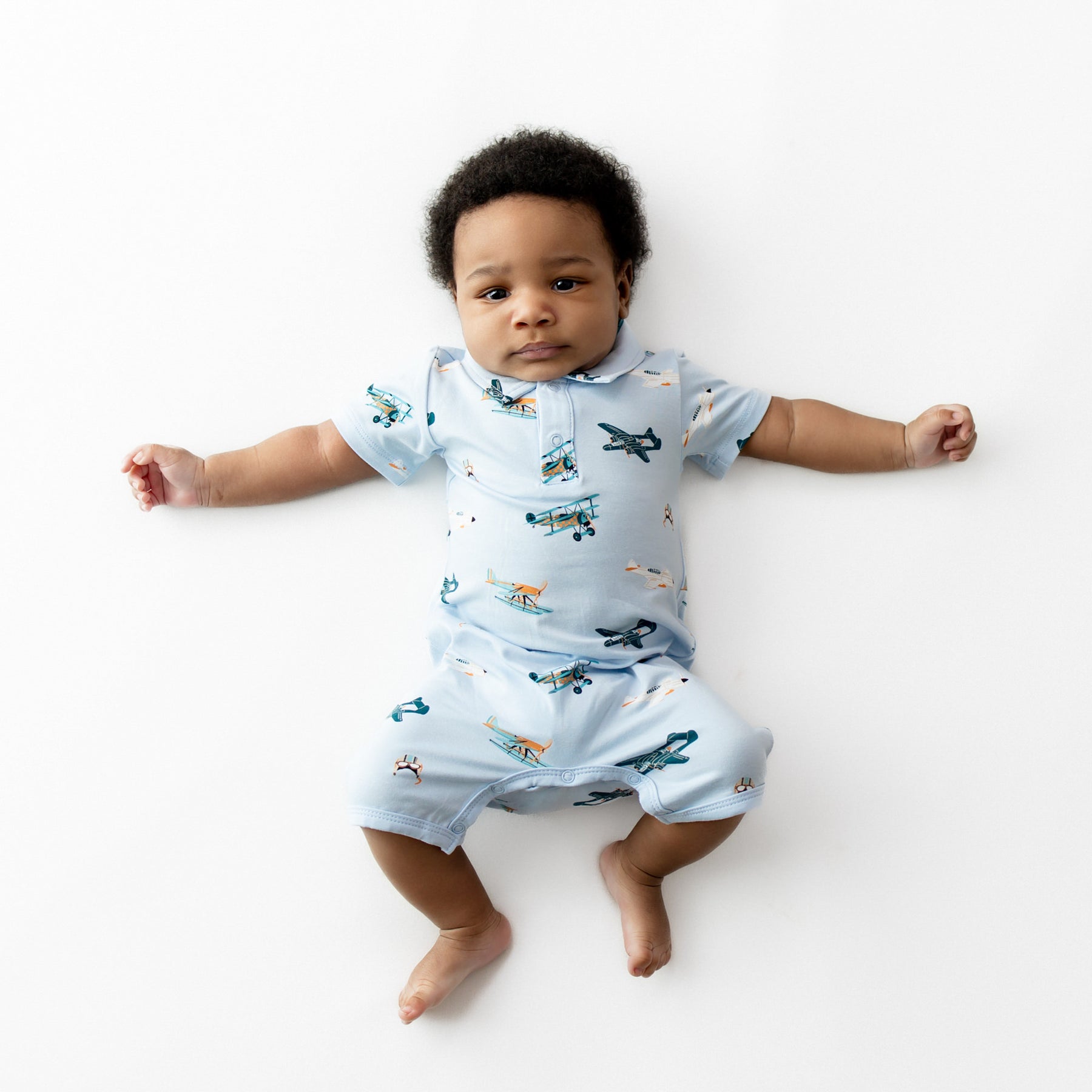 Infant laying stretched out wearing the Polo Shortall in Take Off