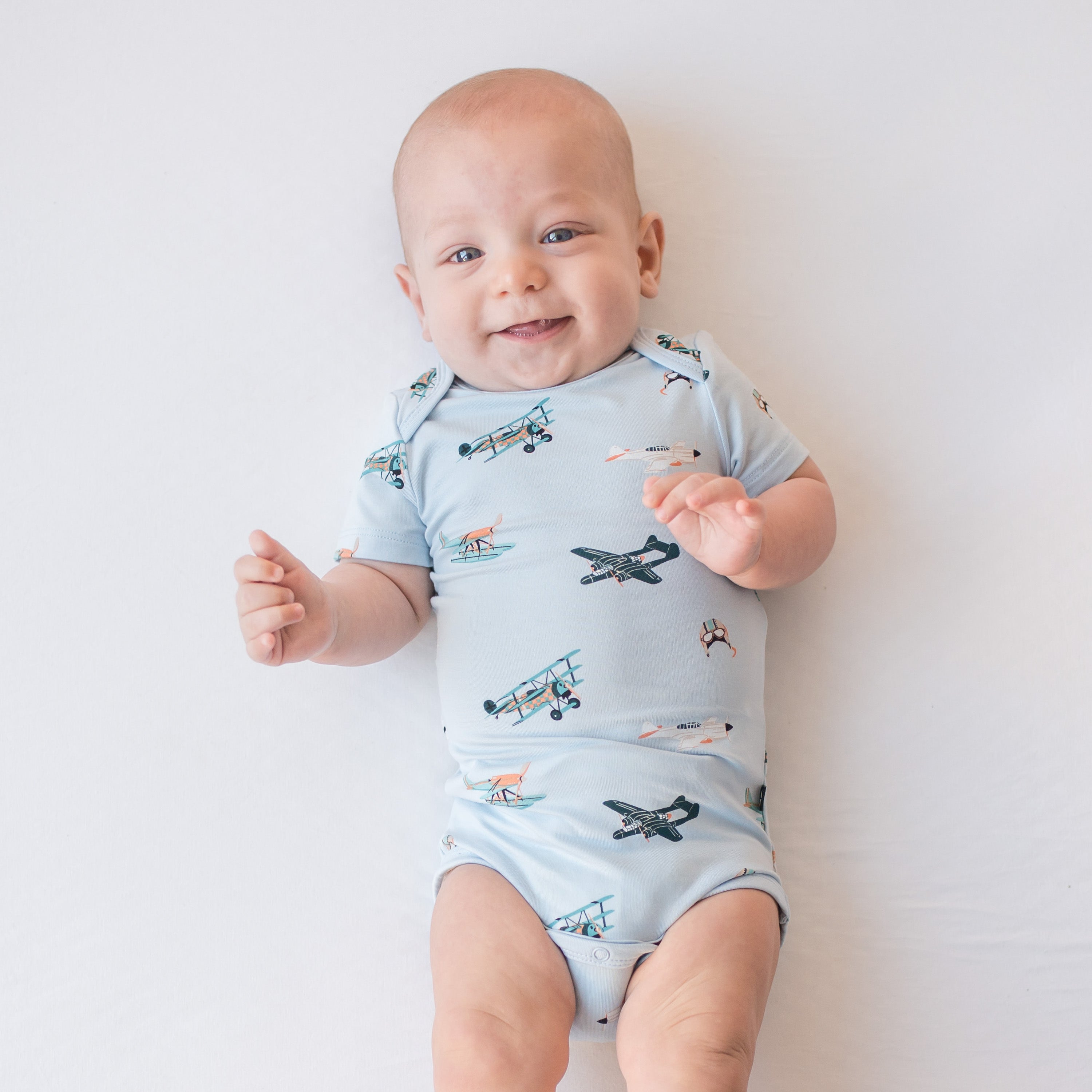 Smiling infant wearing the Bodysuit in Take Off