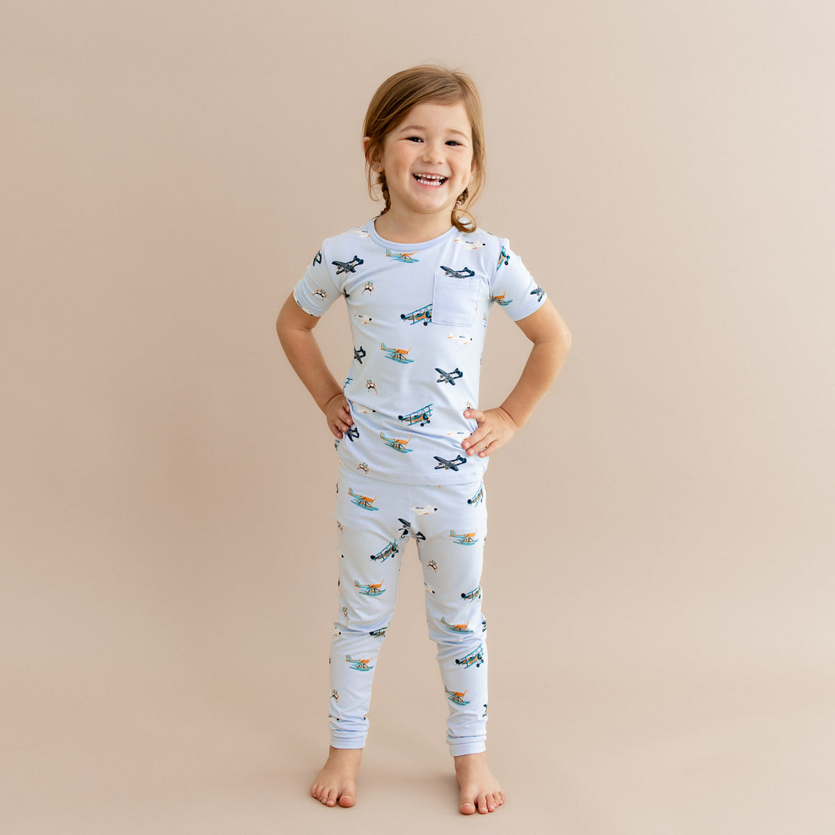 Young girl standing with her hands on her hips wearing the Short Sleeve with Pants Pajamas in Take Off