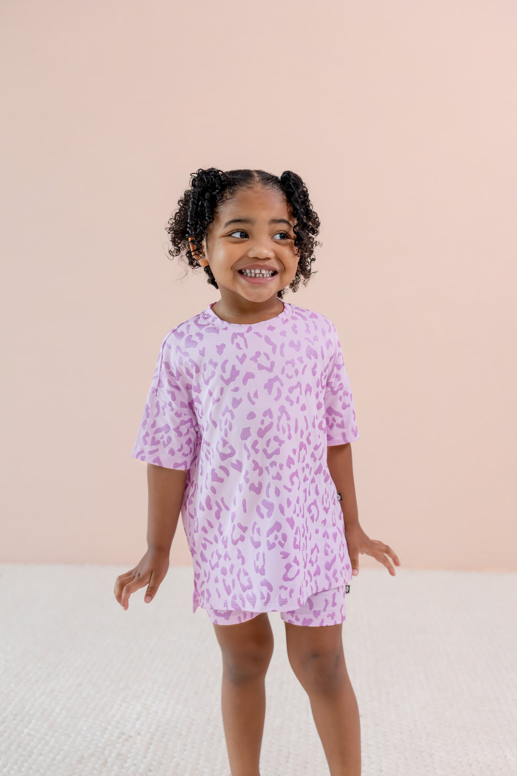 Child wearing Thistle Leopard print Toddler Biker Short set on a beige background