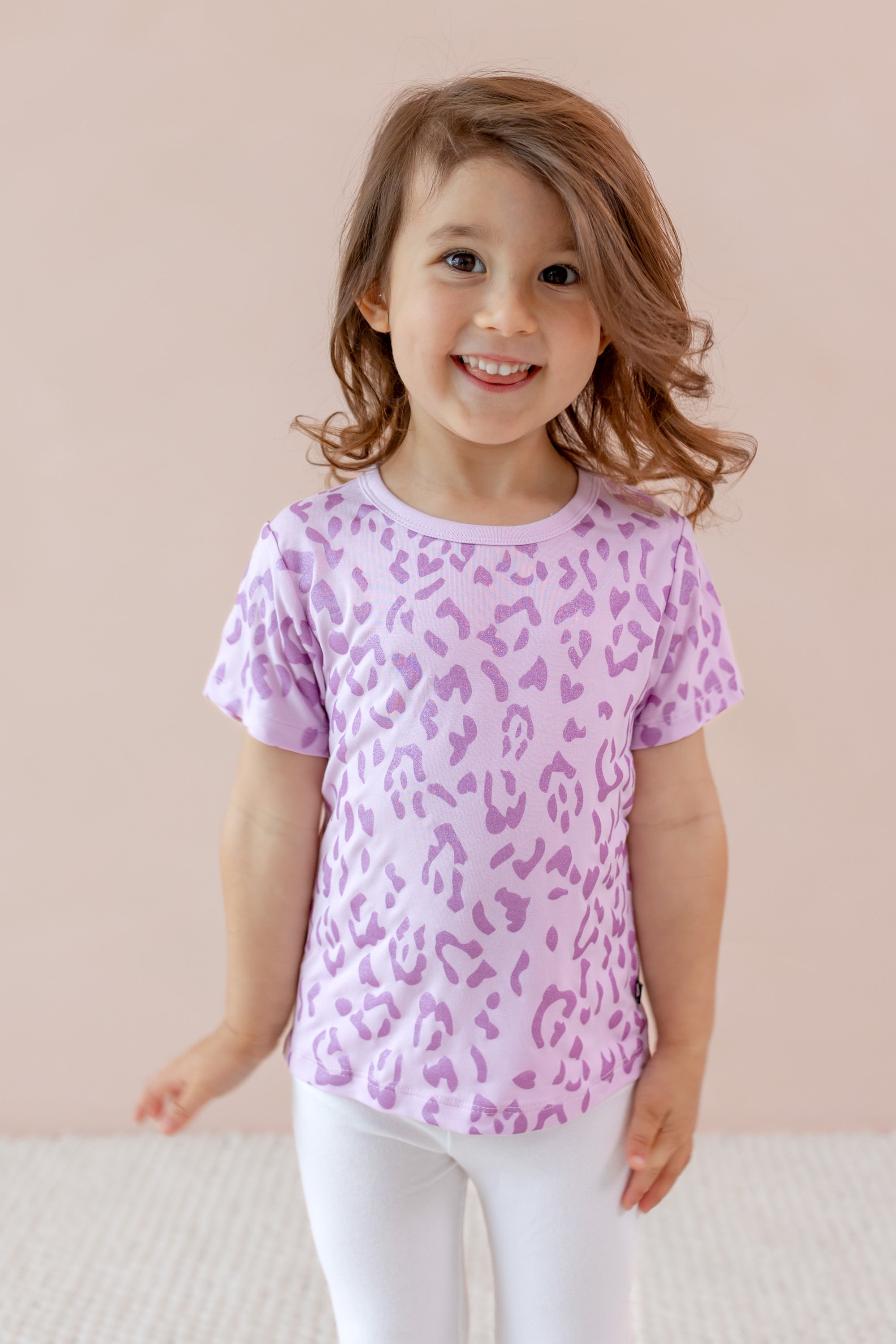 Child wearing Toddler Basic Tee with Thistle Leopard print over a white leggings on a beige background