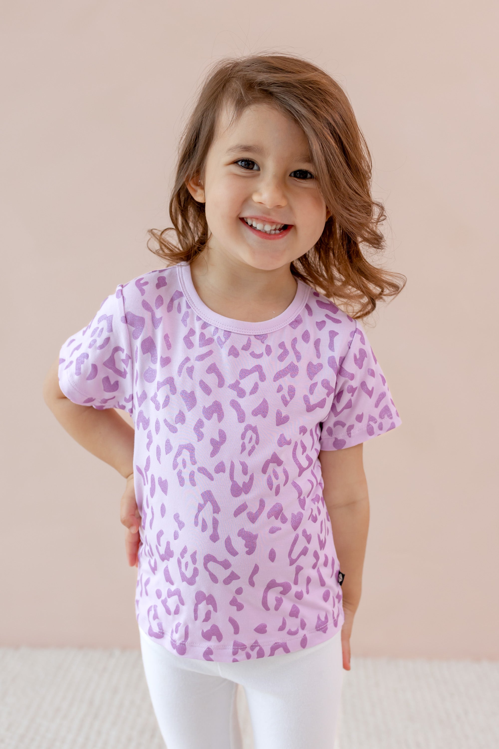 Child wearing Toddler Basic Tee with Thistle Leopard print over a white leggings on a beige background