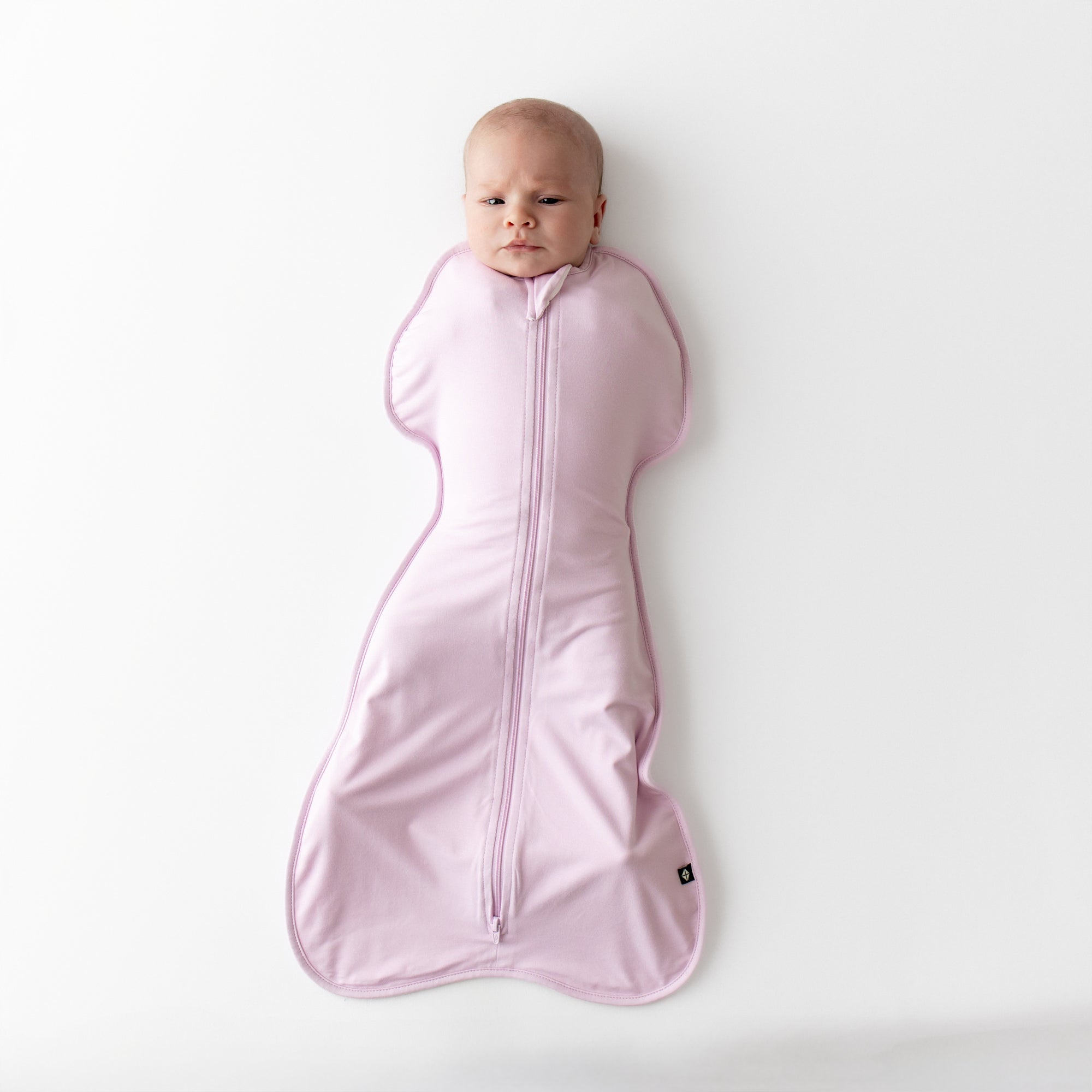 Baby wearing a light purple swaddle bag 